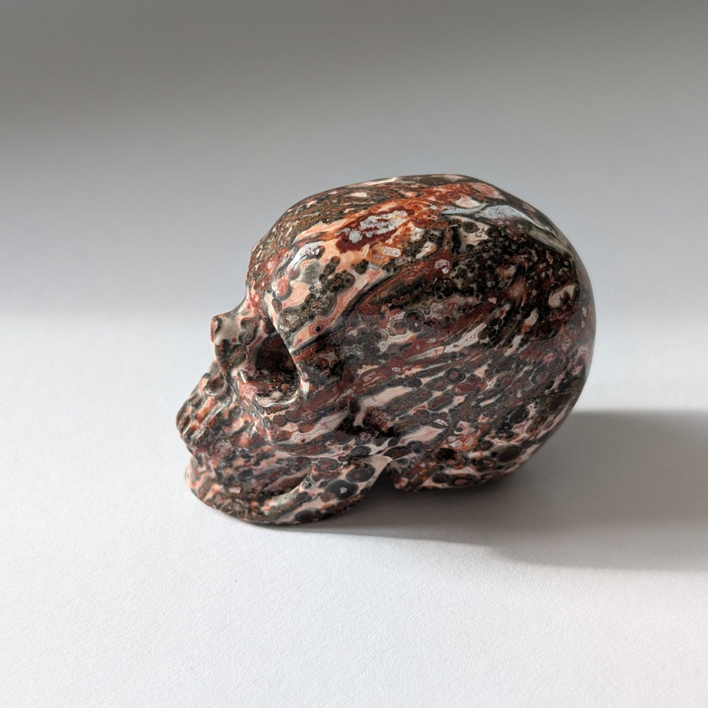 Ein 75g schwerer, handgeschnitzter Kristallschädel 'Tana' aus Rhyolith mit einer markanten, an Leopardenfell erinnernden Musterung.