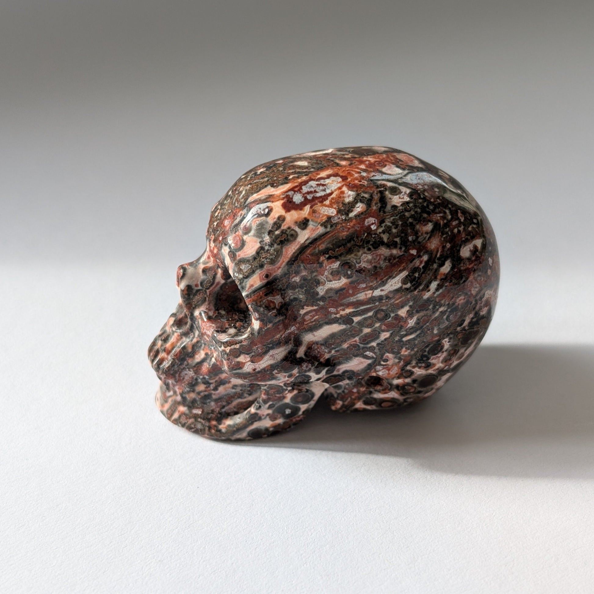 Ein 75g schwerer, handgeschnitzter Kristallschädel 'Tana' aus Rhyolith mit einer markanten, an Leopardenfell erinnernden Musterung.