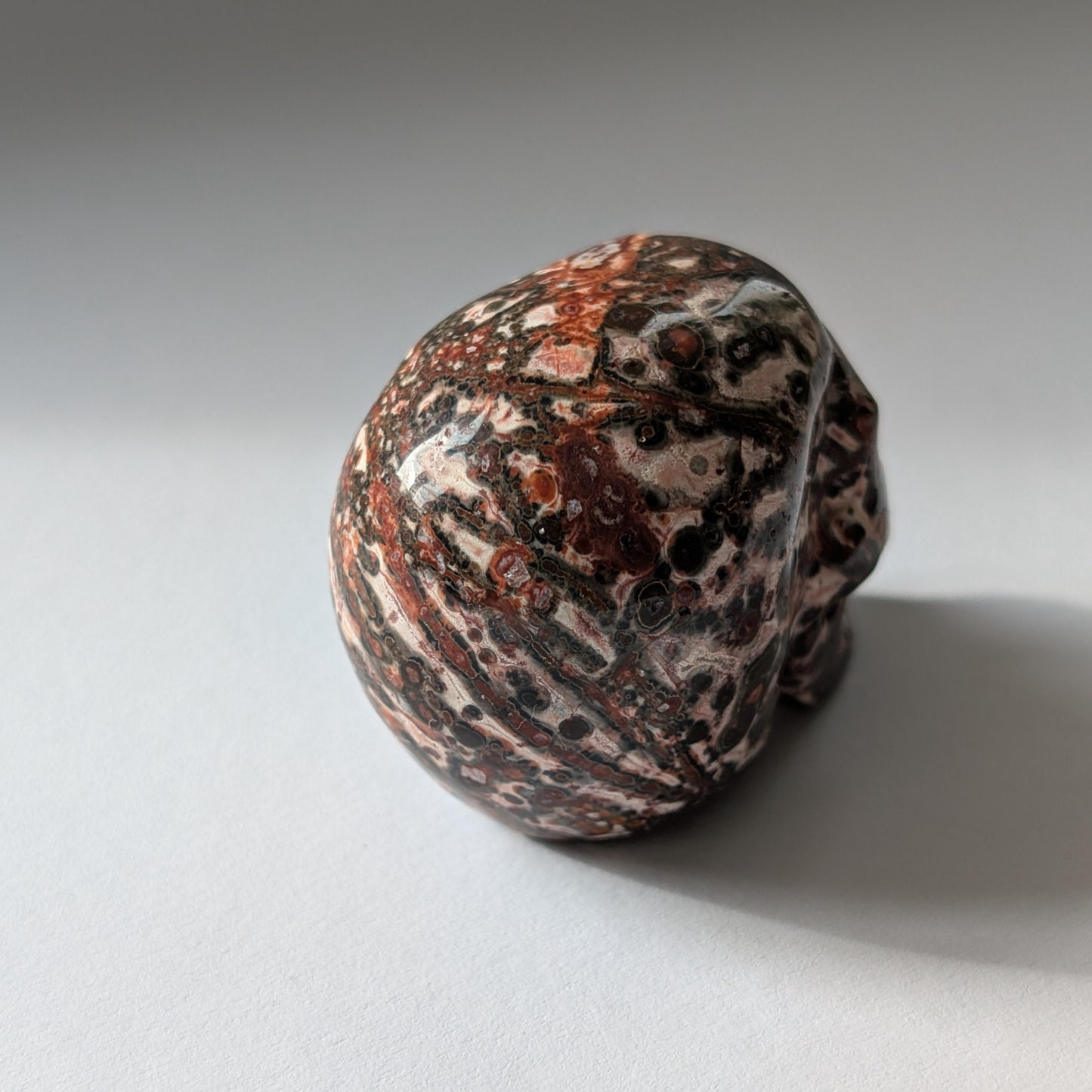 Ein 75g schwerer, handgeschnitzter Kristallschädel 'Tana' aus Rhyolith mit einer markanten, an Leopardenfell erinnernden Musterung.