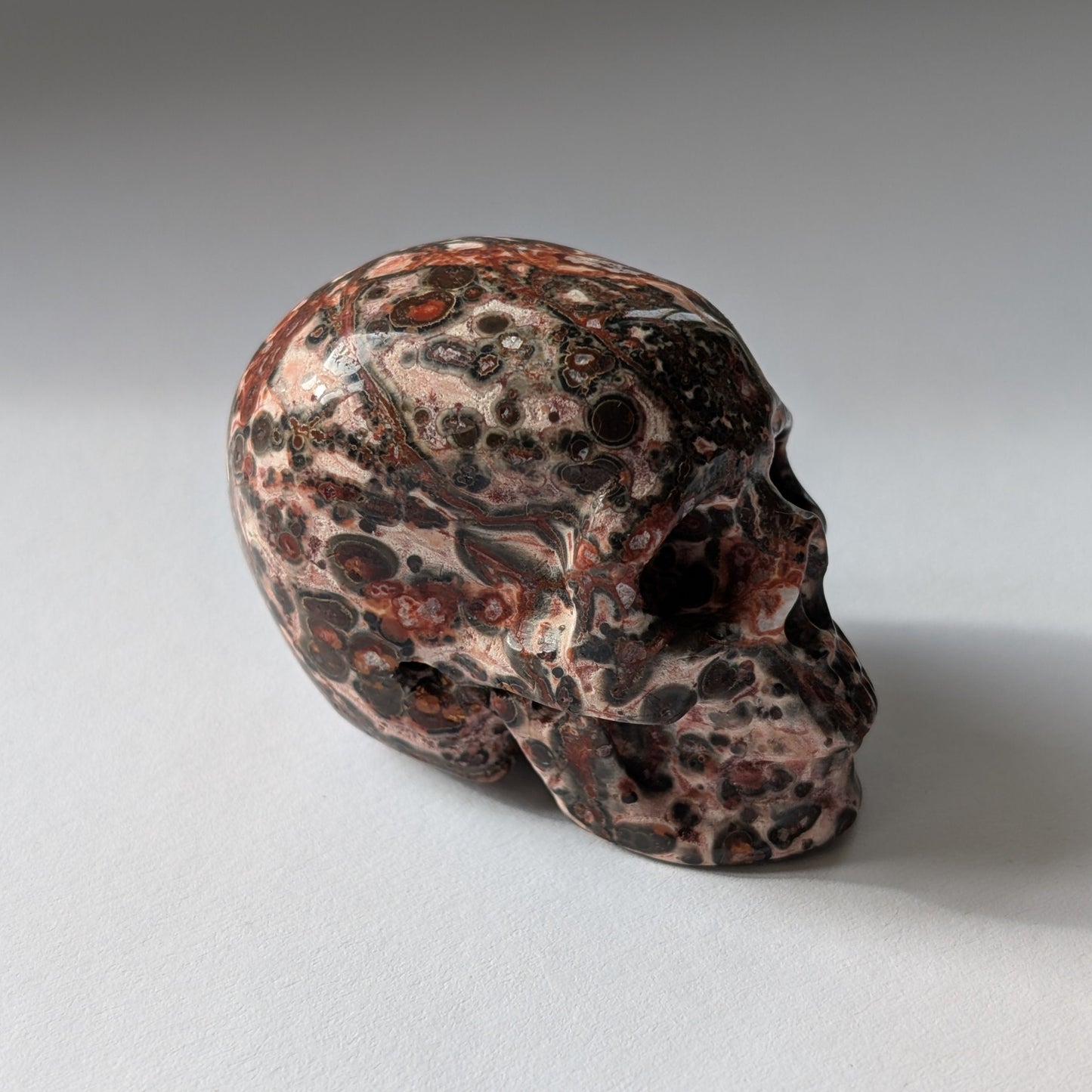 Ein 75g schwerer, handgeschnitzter Kristallschädel 'Tana' aus Rhyolith mit einer markanten, an Leopardenfell erinnernden Musterung.