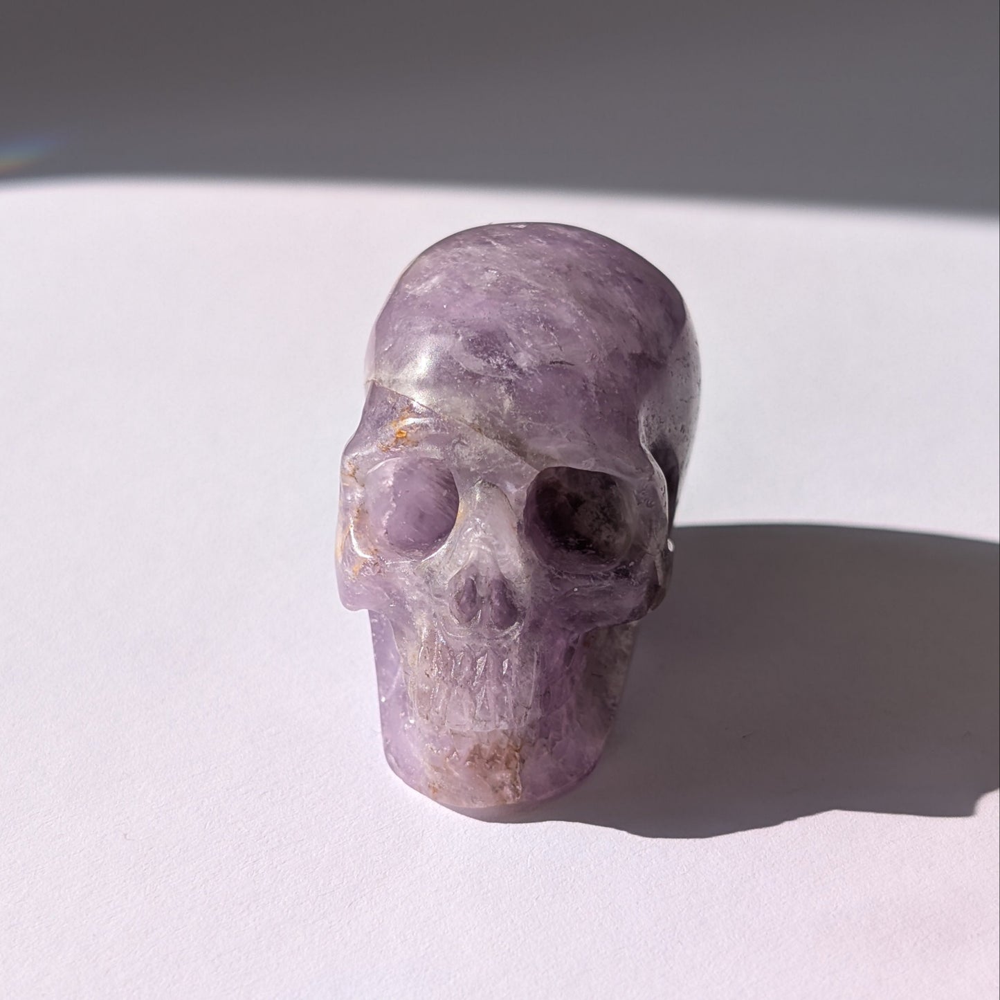 Ein 82g schwerer, handgeschnitzter Kristallschädel 'Der Seelenflüsterer' aus durchscheinendem, violettem Amethyst.