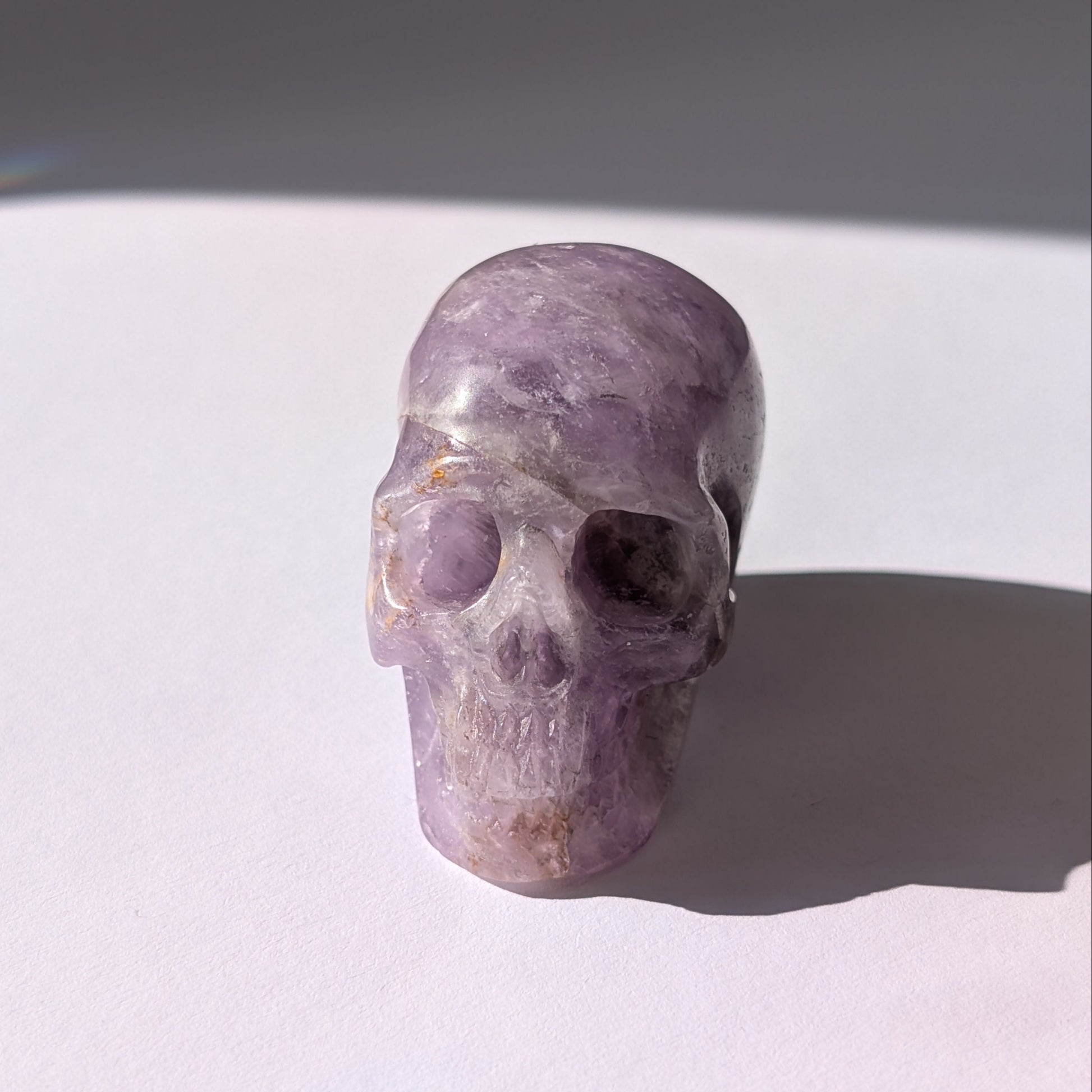 Ein 82g schwerer, handgeschnitzter Kristallschädel 'Der Seelenflüsterer' aus durchscheinendem, violettem Amethyst.