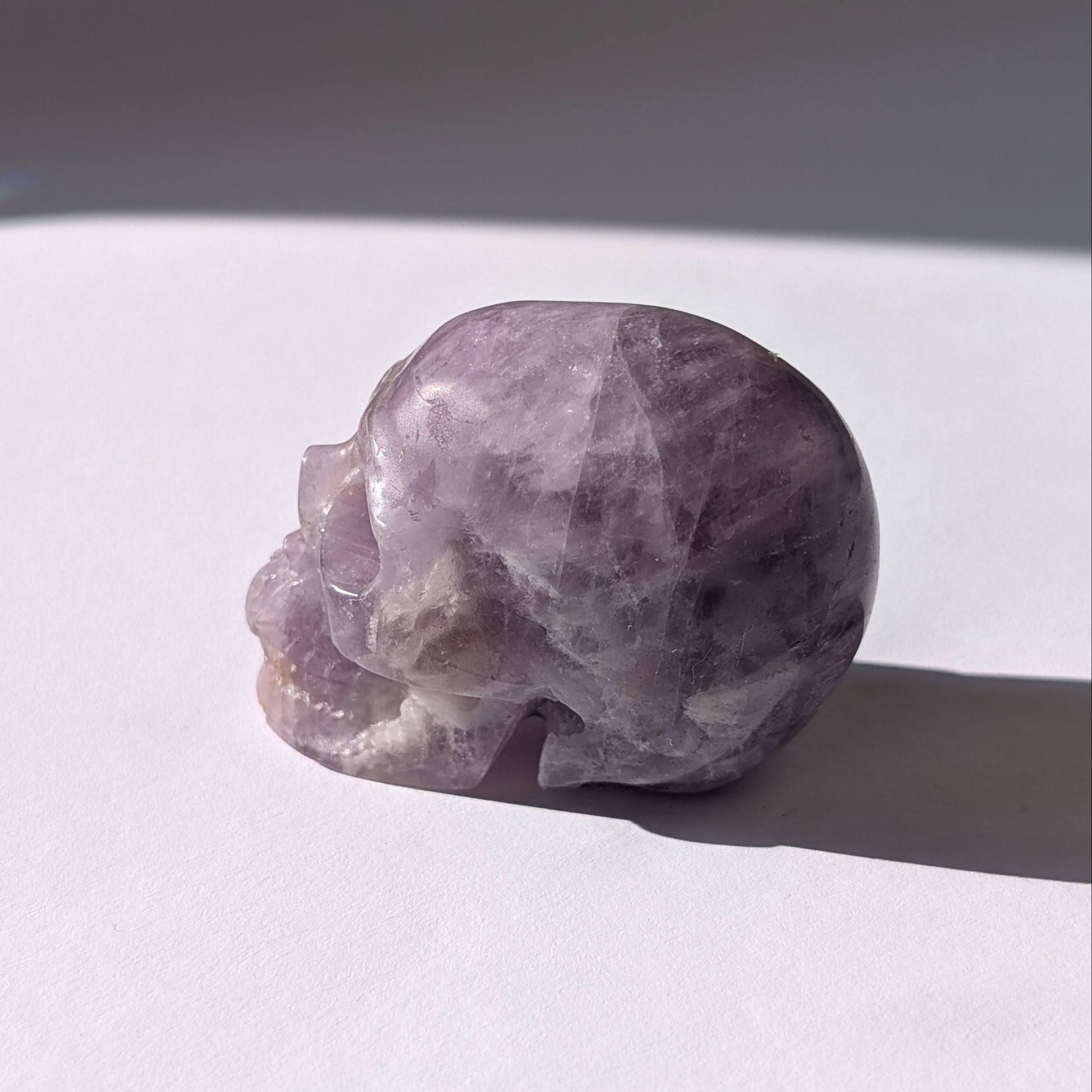 Ein 82g schwerer, handgeschnitzter Kristallschädel 'Der Seelenflüsterer' aus durchscheinendem, violettem Amethyst.