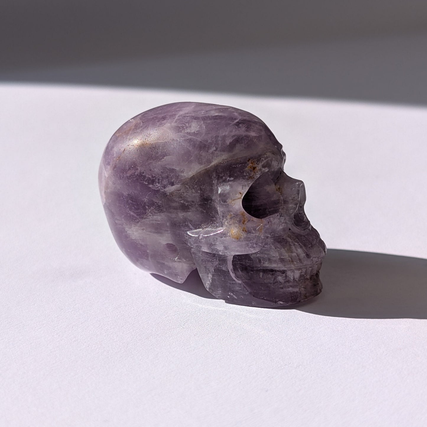 Ein 82g schwerer, handgeschnitzter Kristallschädel 'Der Seelenflüsterer' aus durchscheinendem, violettem Amethyst.