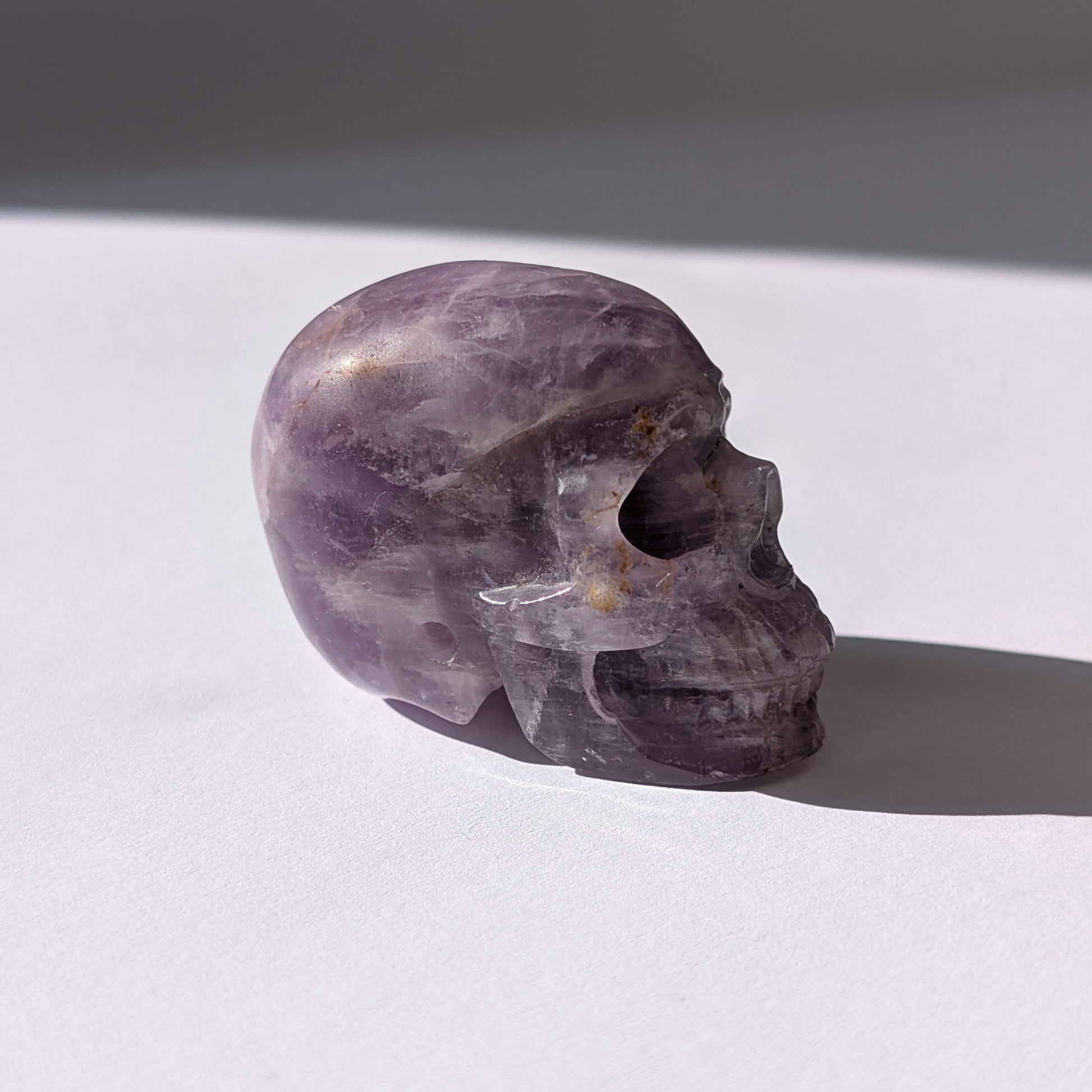 Ein 82g schwerer, handgeschnitzter Kristallschädel 'Der Seelenflüsterer' aus durchscheinendem, violettem Amethyst.