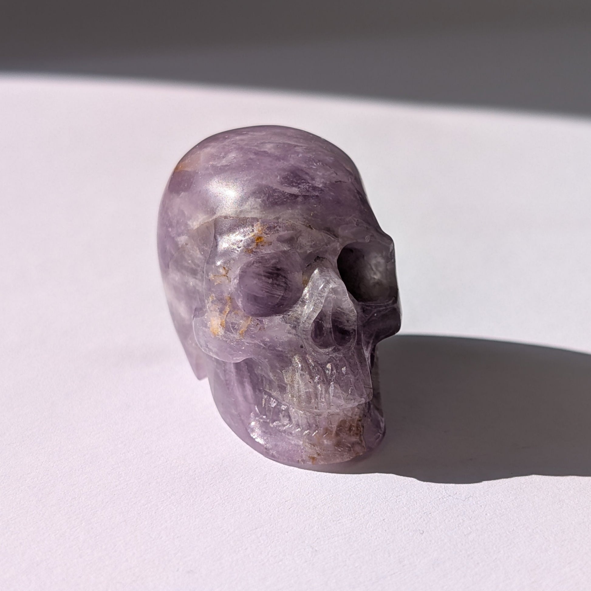 Ein 82g schwerer, handgeschnitzter Kristallschädel 'Der Seelenflüsterer' aus durchscheinendem, violettem Amethyst.