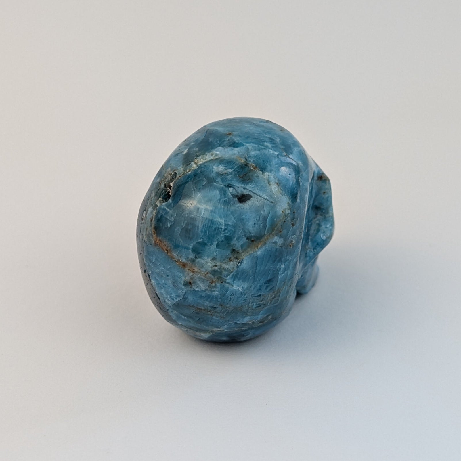 Ein 85g schwerer, handgeschnitzter Kristallschädel 'Sergil' aus leuchtend blau-grünem Apatit, der eine motivierende Energie ausstrahlt.