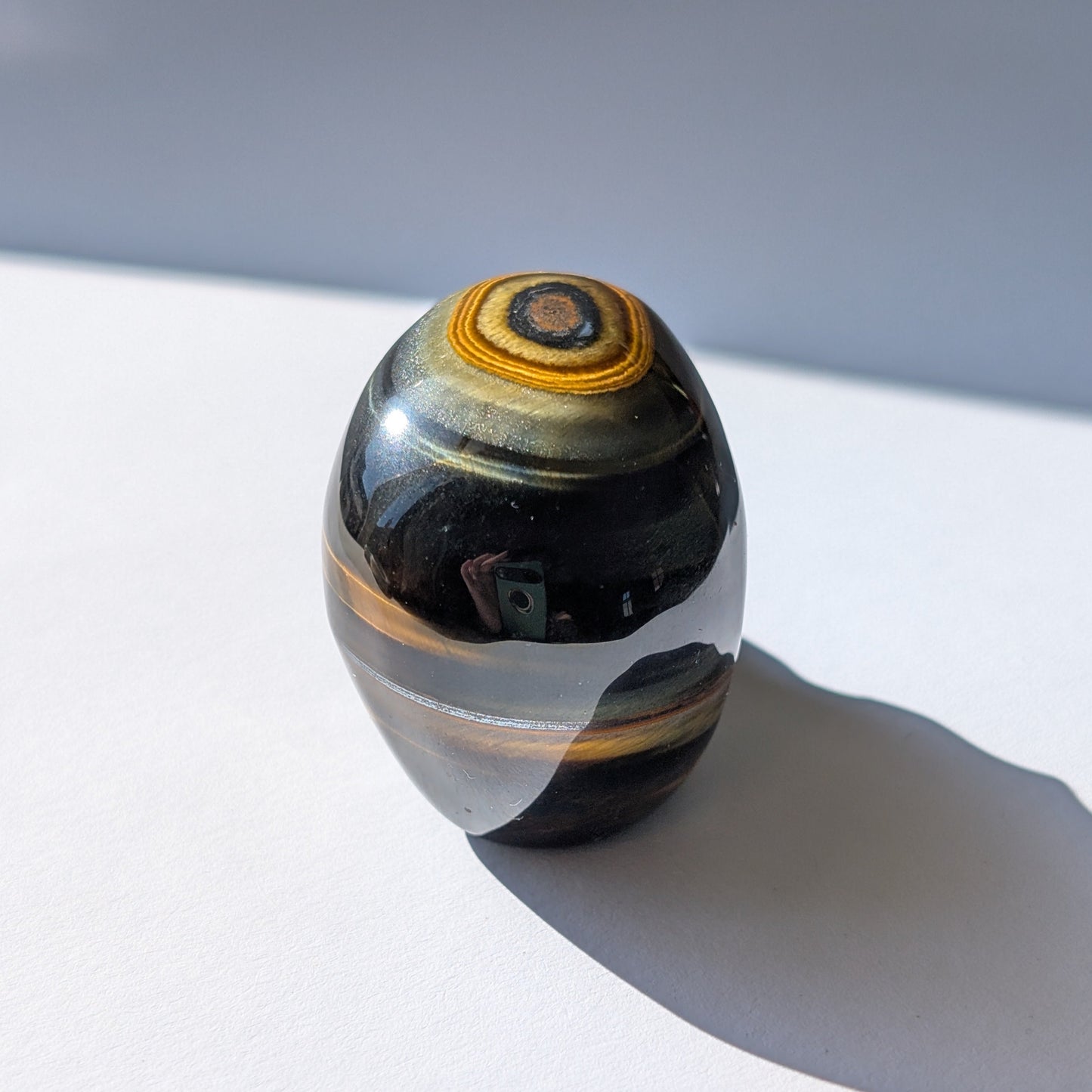 Ein 92g schwerer Kristallschädel 'Erlin' aus Blau-Gold Tigerauge mit einem perfekt geformten, konzentrischen Auge auf dem Scheitel.