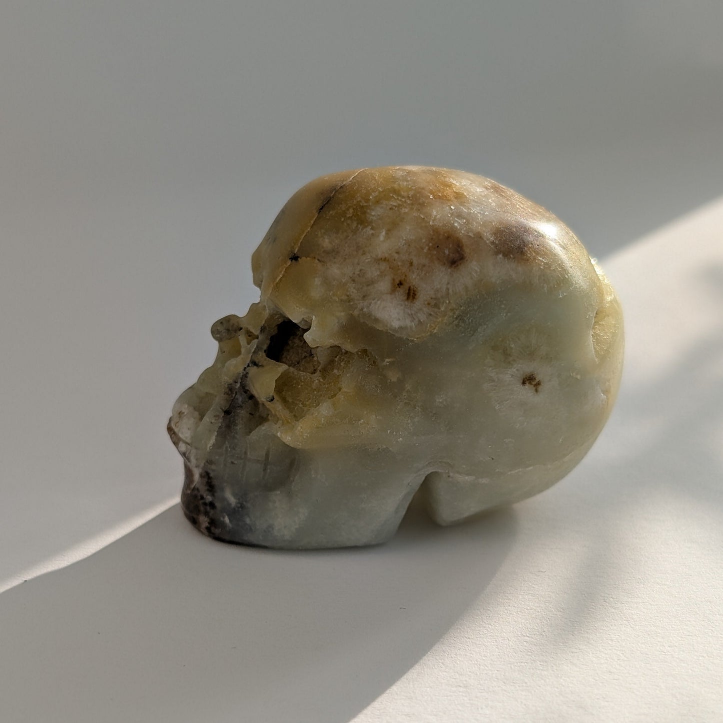 Ein 99g schwerer, handgeschnitzter Kristallschädel 'Amillo' aus sanftem, cremefarbenem Mikroklin, der eine hoffnungsvolle Energie ausstrahlt.