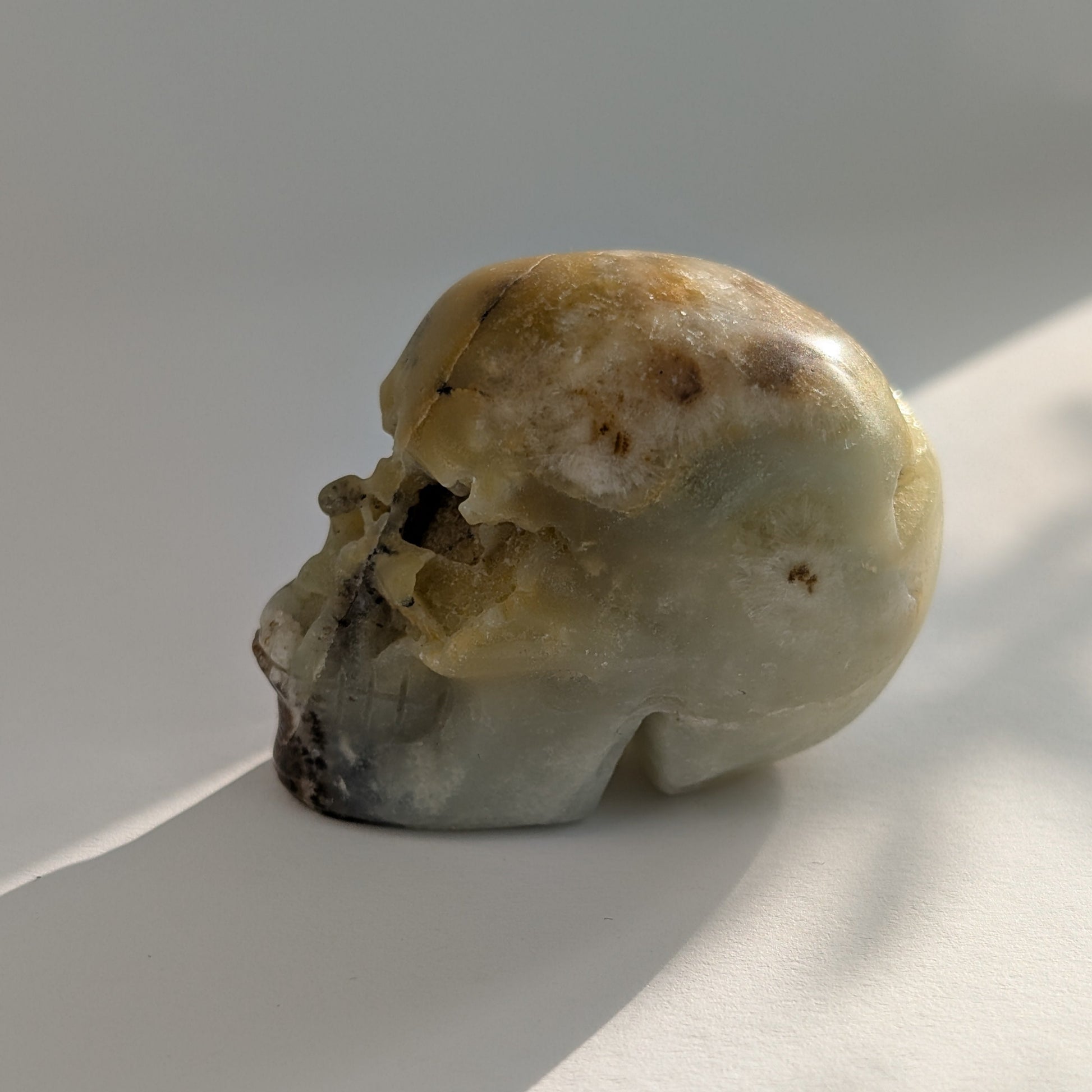 Ein 99g schwerer, handgeschnitzter Kristallschädel 'Amillo' aus sanftem, cremefarbenem Mikroklin, der eine hoffnungsvolle Energie ausstrahlt.
