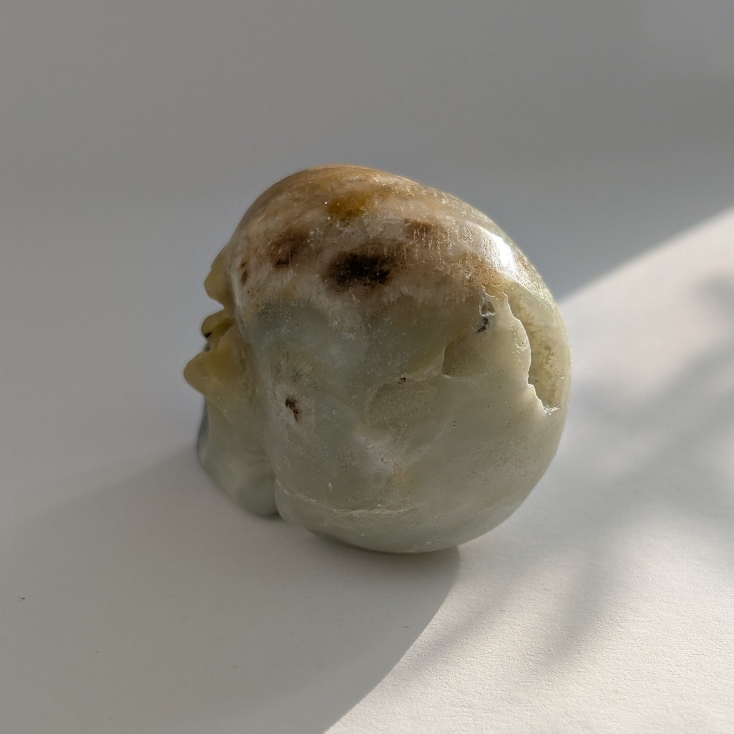Ein 99g schwerer, handgeschnitzter Kristallschädel 'Amillo' aus sanftem, cremefarbenem Mikroklin, der eine hoffnungsvolle Energie ausstrahlt.