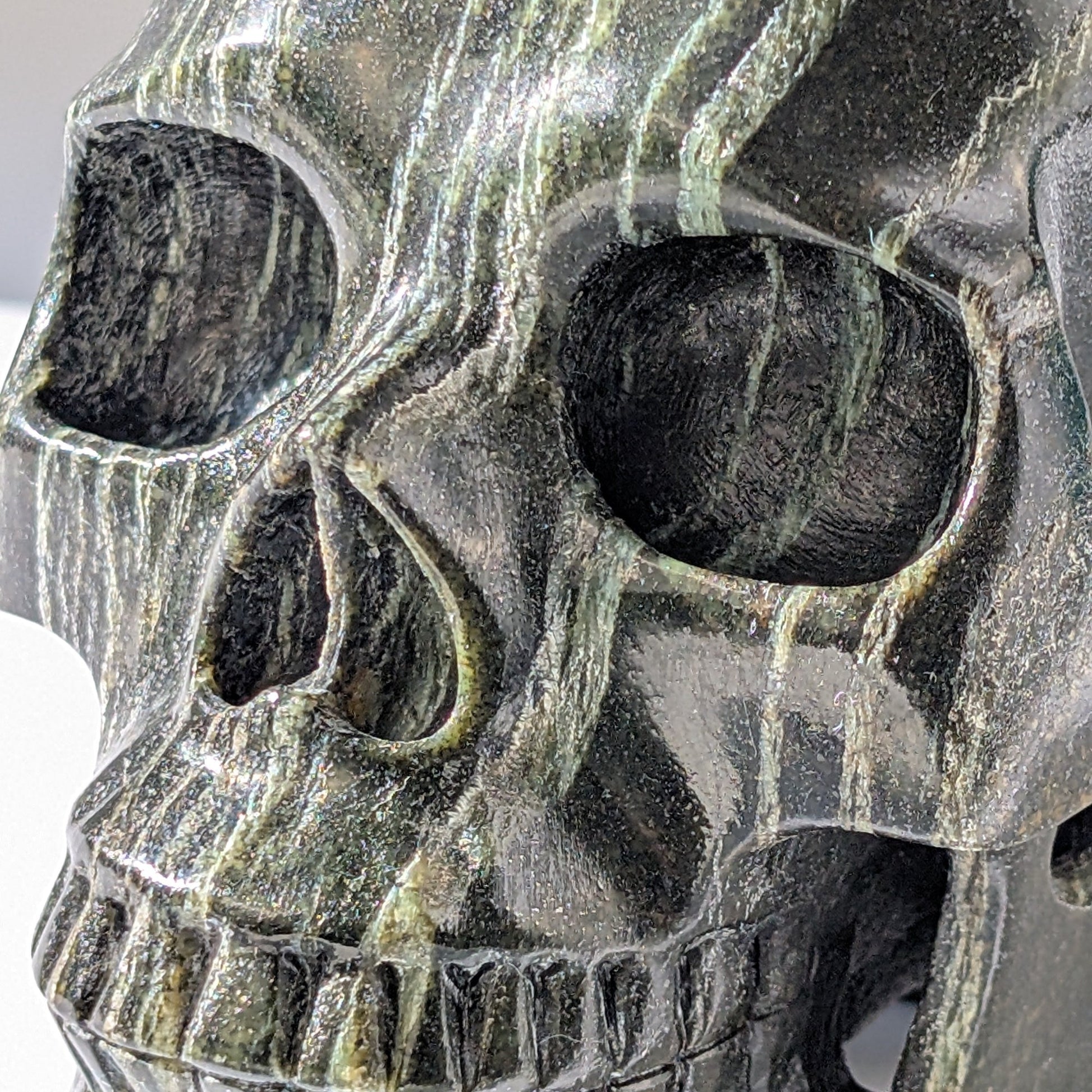 Ein monumentaler, 1346g schwerer Kristallschädel 'Der Wächter der Lebenskraft' aus Serpentin mit einem hypnotisierenden, silbrig-grünen Schimmer.