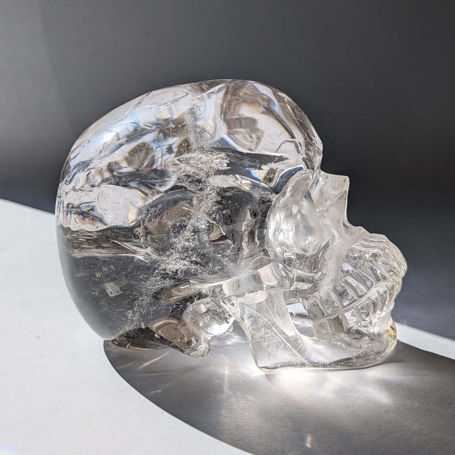 Ein monumentaler, 1450g schwerer Golden Healer Bergkristall-Schädel 'Der Lichtbringer' mit unzähligen leuchtenden Regenbogen-Einschlüssen.