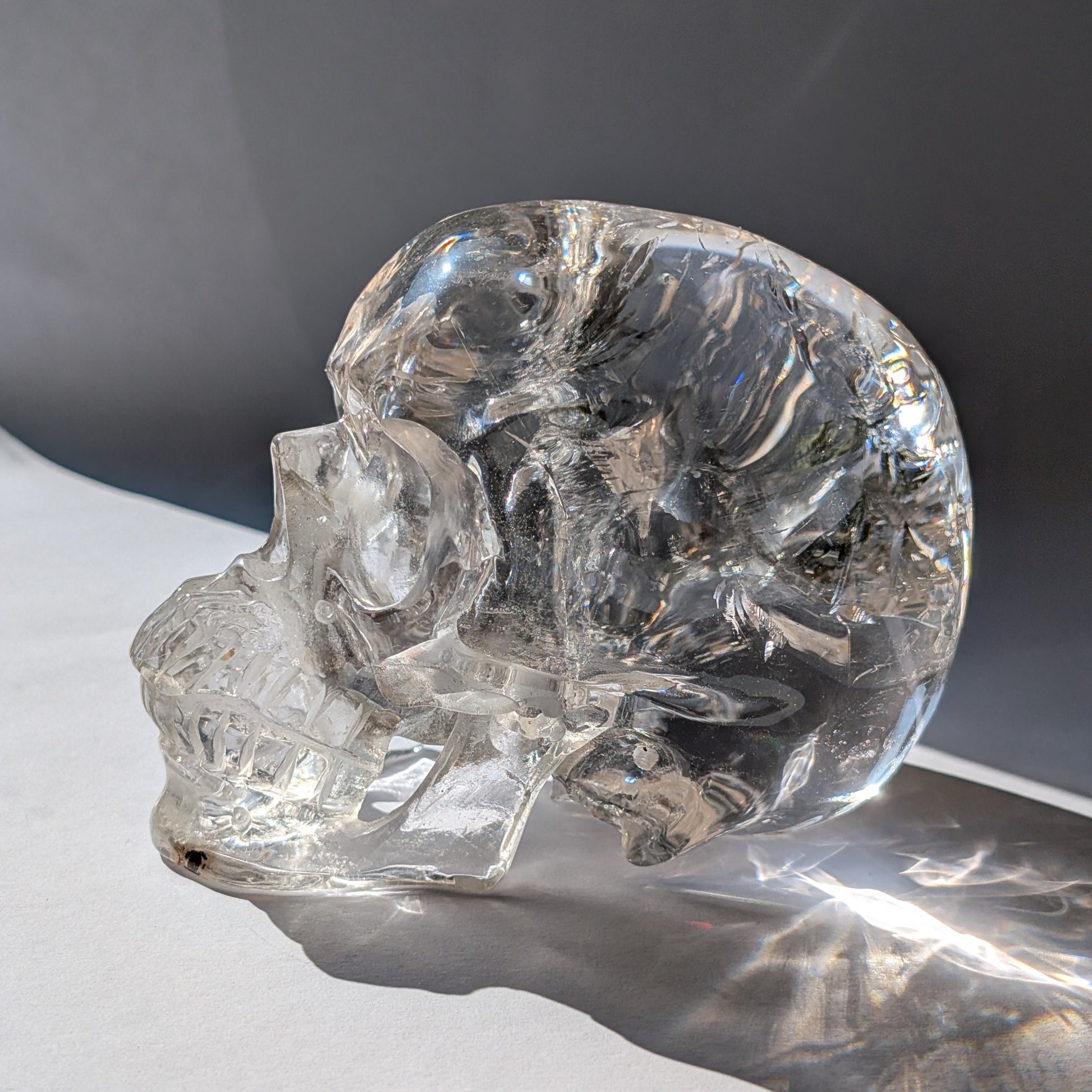 Ein monumentaler, 1450g schwerer Golden Healer Bergkristall-Schädel 'Der Lichtbringer' mit unzähligen leuchtenden Regenbogen-Einschlüssen.