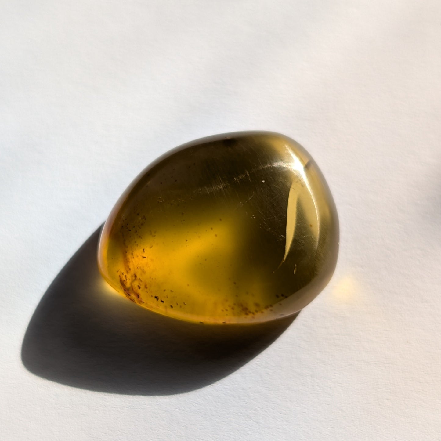 Ein polierter Bicolor-Bernstein 'Der Tropfen der Sonne' in natürlicher Freiform, der von Cognac-braun zu leuchtendem Sonnengelb übergeht.