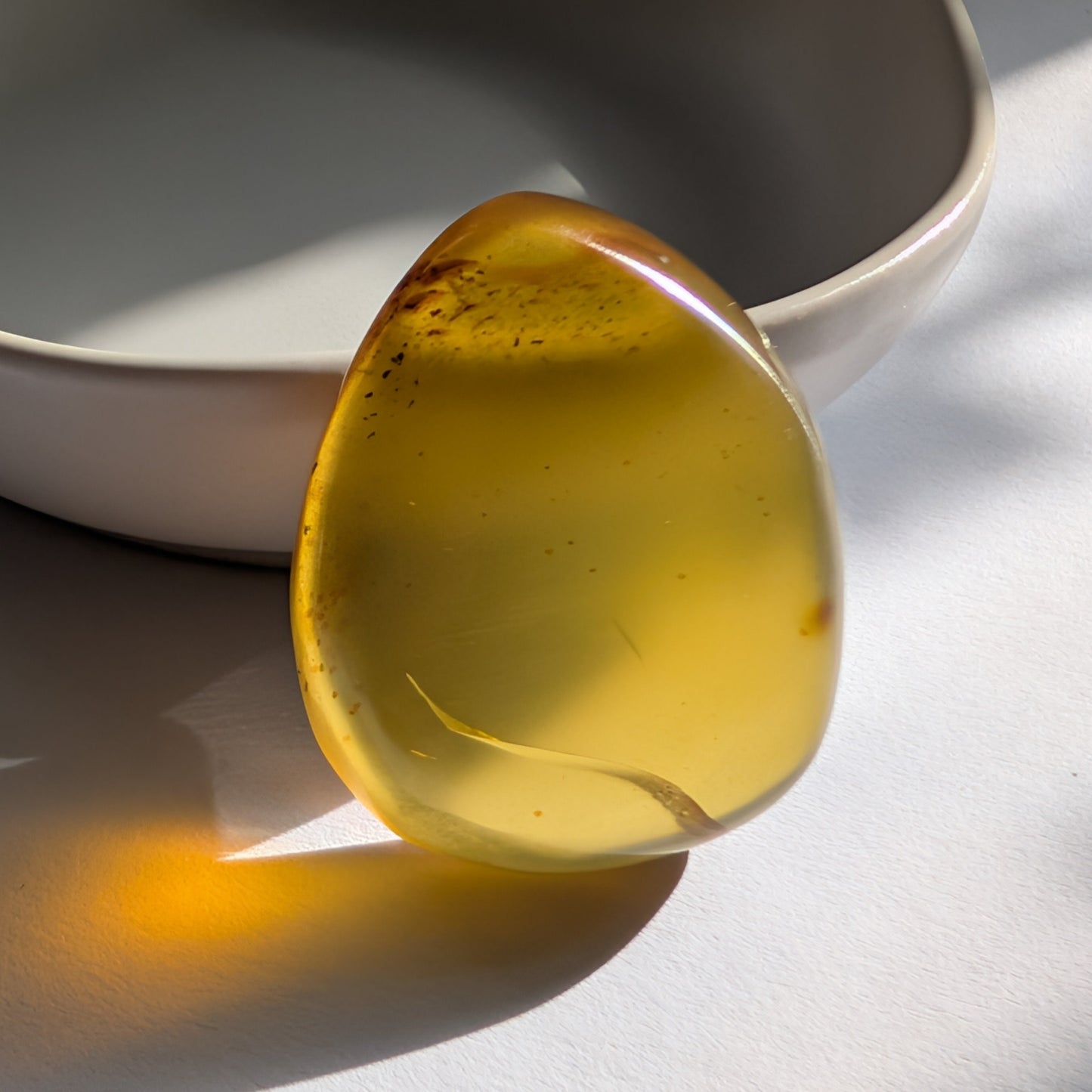 Ein polierter Bicolor-Bernstein 'Der Tropfen der Sonne' in natürlicher Freiform, der von Cognac-braun zu leuchtendem Sonnengelb übergeht.