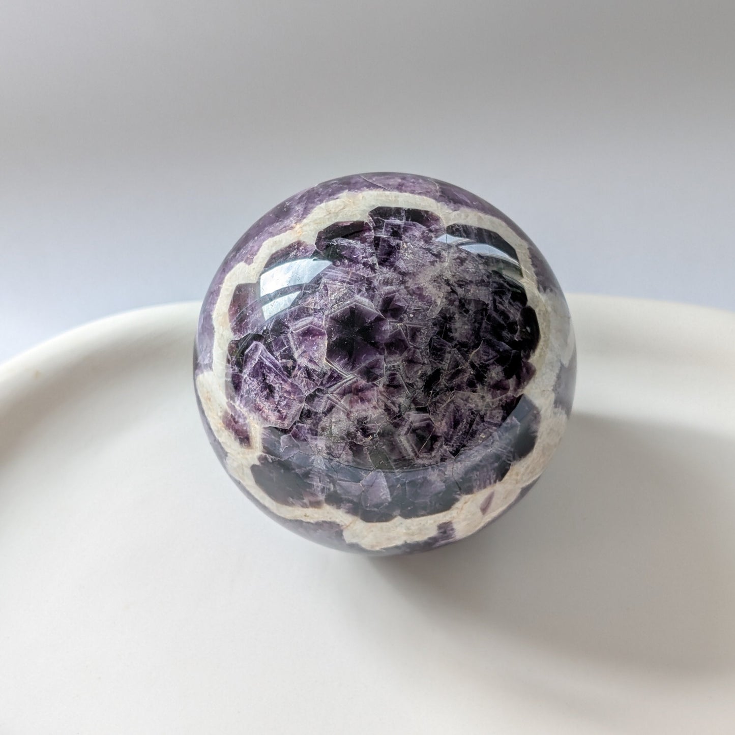 Eine 468g schwere, polierte Kugel aus Chevron Amethyst 'Das Orakel der Seele' mit markanten violetten und weißen Bändern.