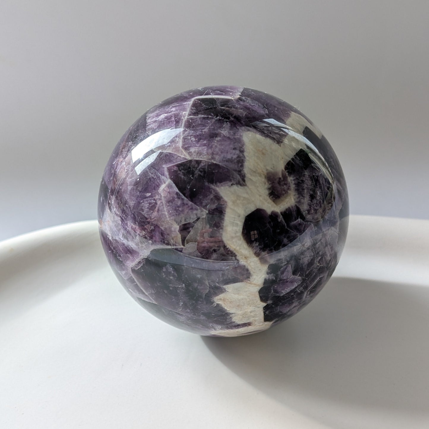 Eine 468g schwere, polierte Kugel aus Chevron Amethyst 'Das Orakel der Seele' mit markanten violetten und weißen Bändern.
