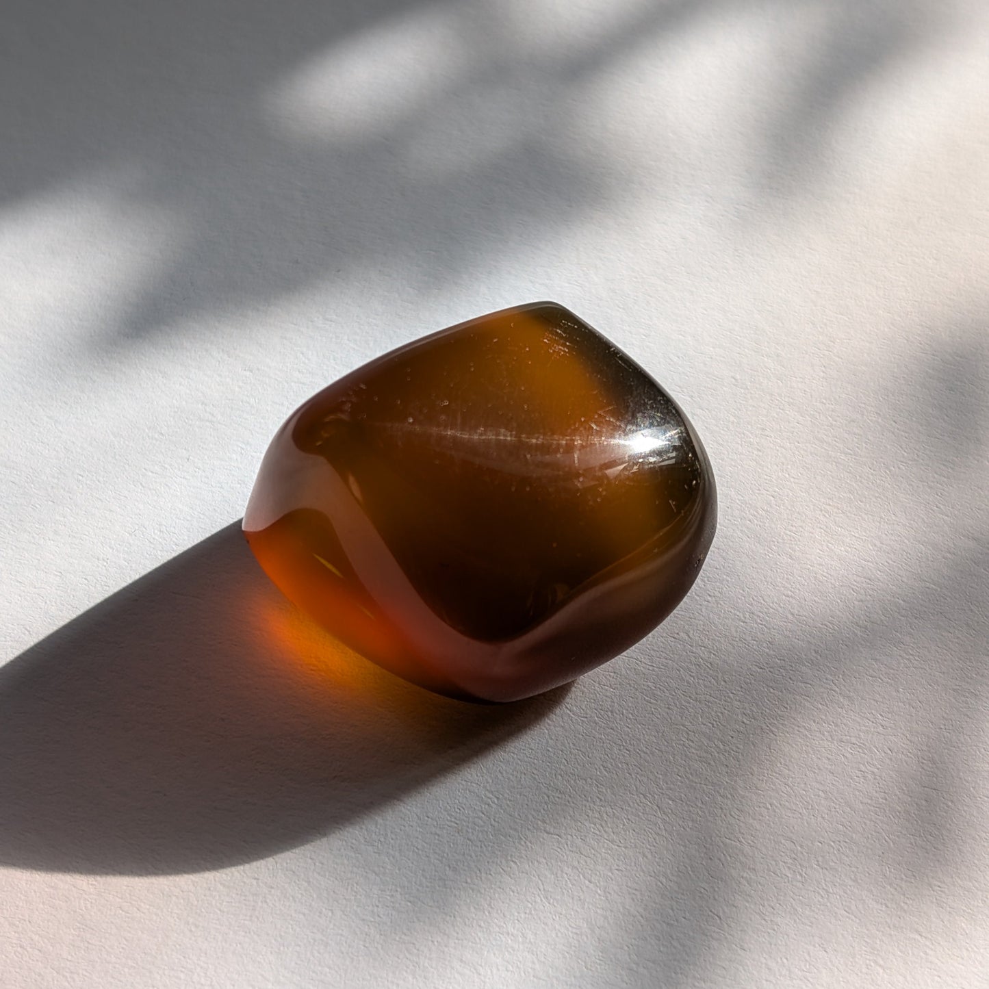 Eleganter Bicolor-Bernstein 'Der Seelenwärmer' in natürlicher Freiform, der sanft von tiefem Rot in einen goldenen Cognac-Ton übergeht.