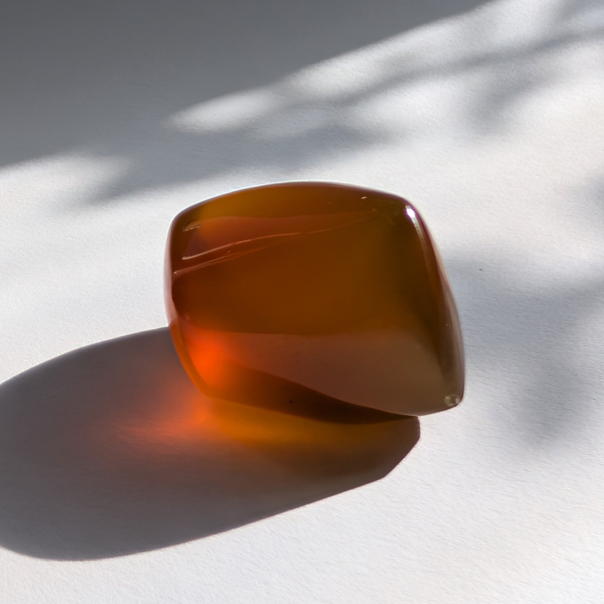 Eleganter Bicolor-Bernstein 'Der Seelenwärmer' in natürlicher Freiform, der sanft von tiefem Rot in einen goldenen Cognac-Ton übergeht.