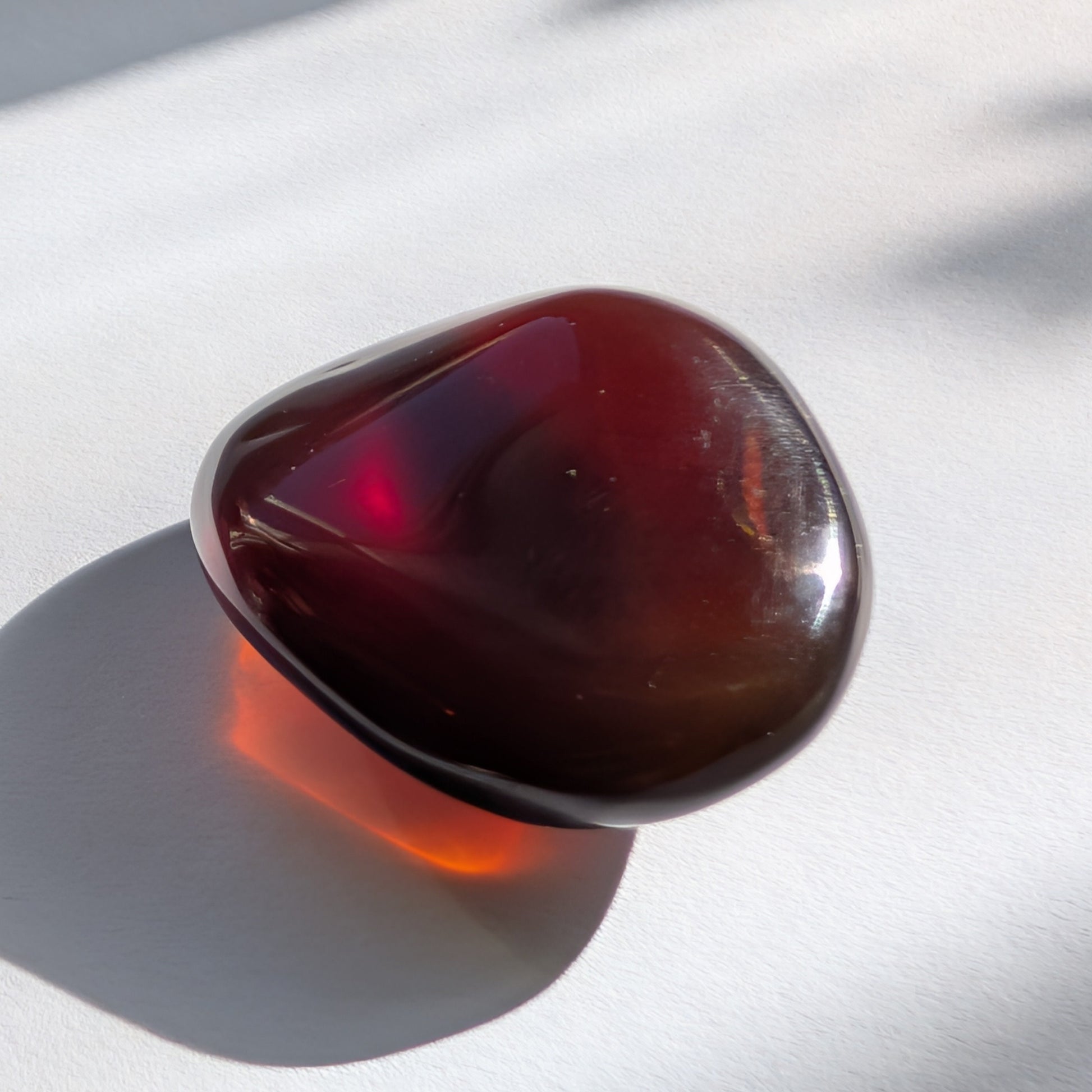 Eleganter Bicolor-Bernstein 'Herz der Dämmerung' in natürlicher Freiform, der sanft von tiefem Rot in einen goldenen Cognac-Ton übergeht.