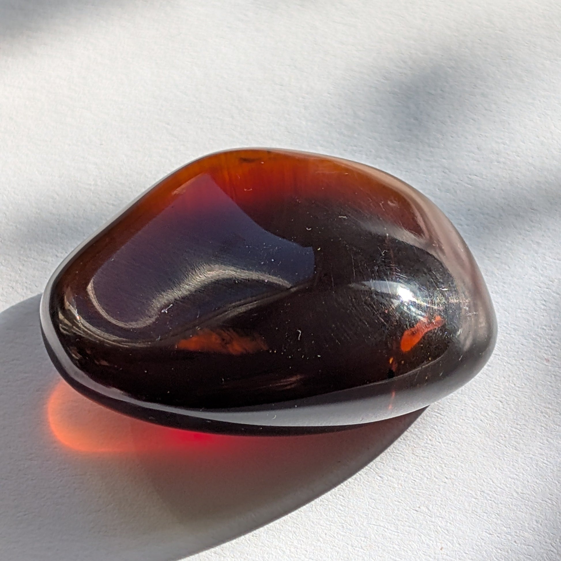 Eleganter Bicolor-Bernstein 'Herz der Dämmerung' in natürlicher Freiform, der sanft von tiefem Rot in einen goldenen Cognac-Ton übergeht.