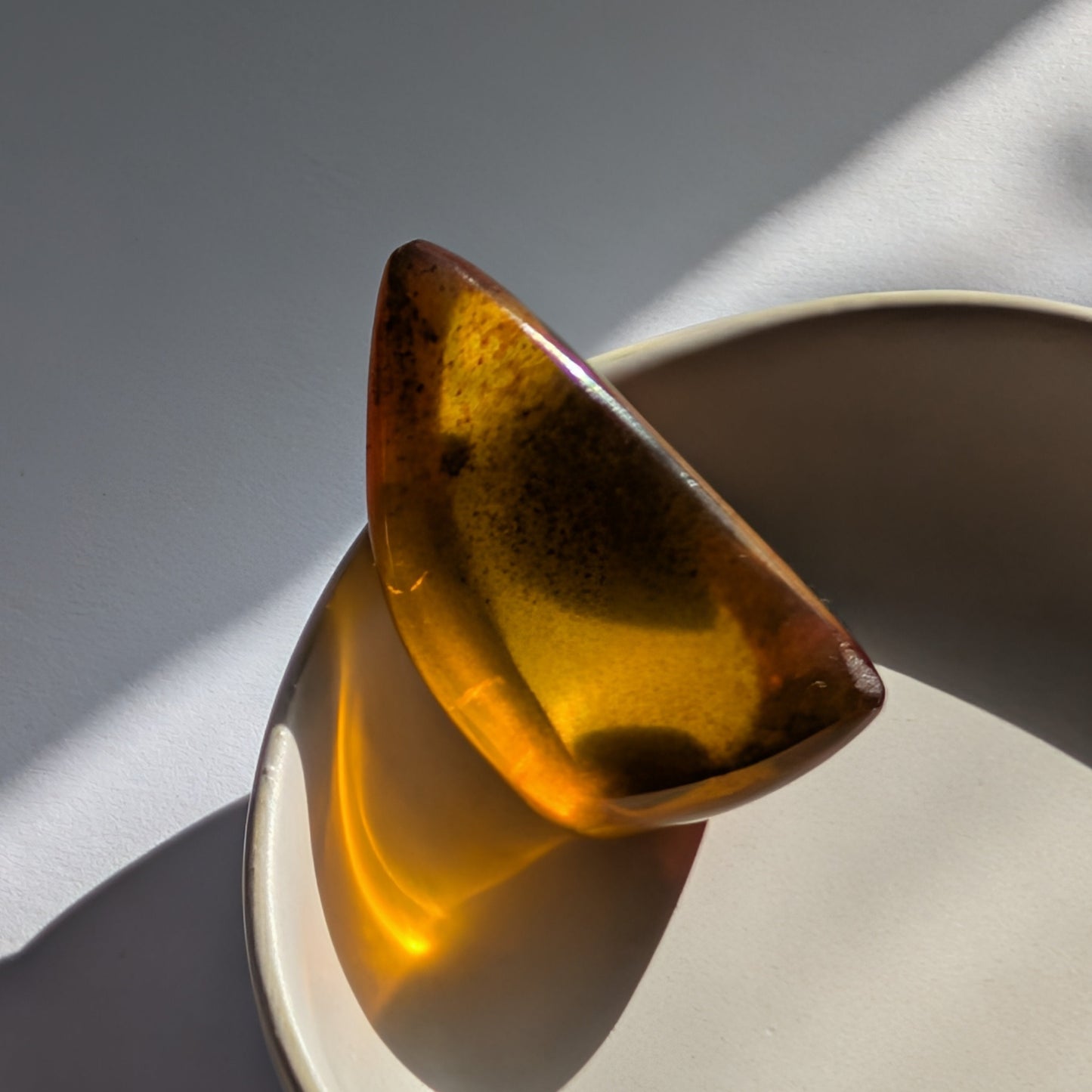 Eleganter, von Natur aus tropfenförmiger Bicolor-Bernstein 'Die Träne der Sonne', der von tiefem Kirschrot zu leuchtendem Gold schimmert.