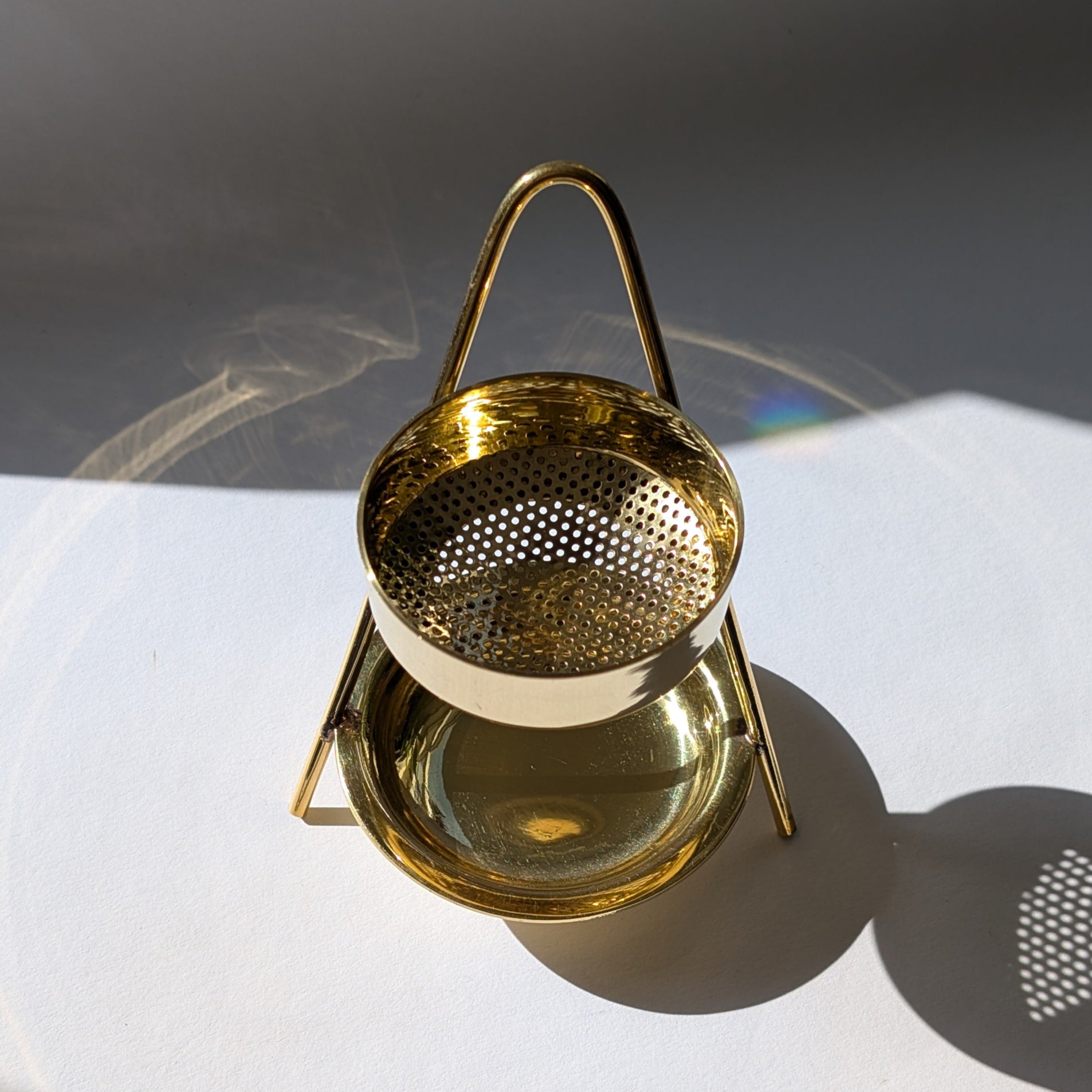 Elegantes, goldenes Räucherstövchen 'Altar der Transformation' aus Messing mit Sieb auf weißem Grund.