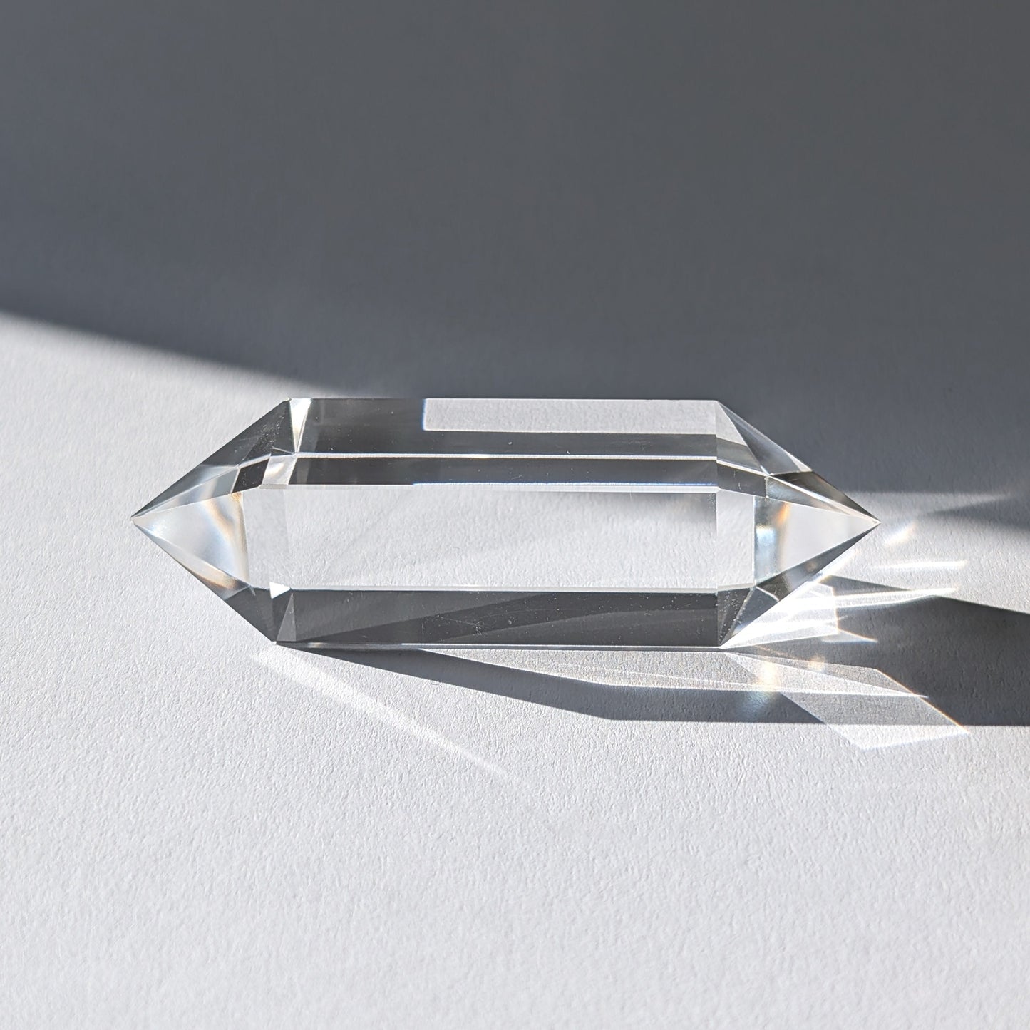 Entdecke diesen reinen Vogel-Stab (69g) aus wasserklarem Bergkristall. Ein 4-seitiger Doppelender für klare Energiearbeit, Erdung & Meditation.