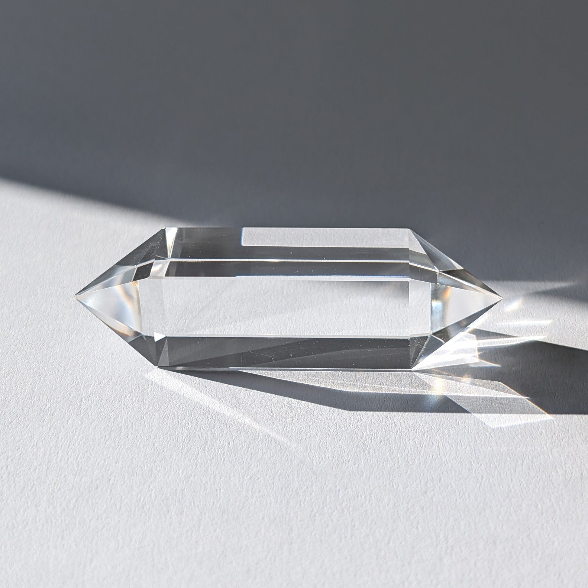 Entdecke diesen reinen Vogel-Stab (69g) aus wasserklarem Bergkristall. Ein 4-seitiger Doppelender für klare Energiearbeit, Erdung & Meditation.