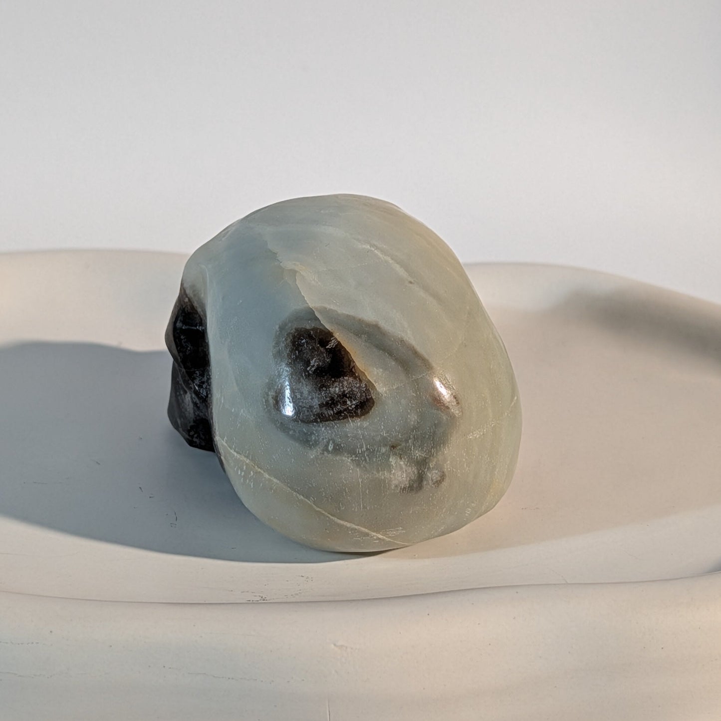 Gefährlich wirkender Kristallschädel Gyffard aus aschfahlem Magnesit 300g durchzogen von harten schwarzen Rissen