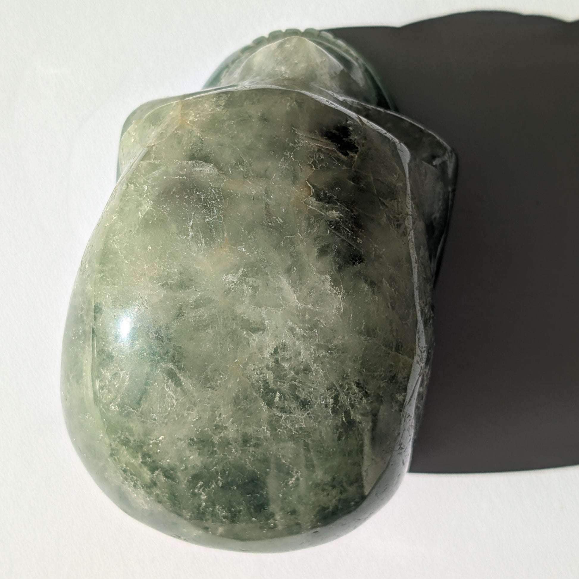 Großer Kristallschädel "Gulkar" (fast 2kg) aus leuchtend grünem Fluorit, seitlich beleuchtet.