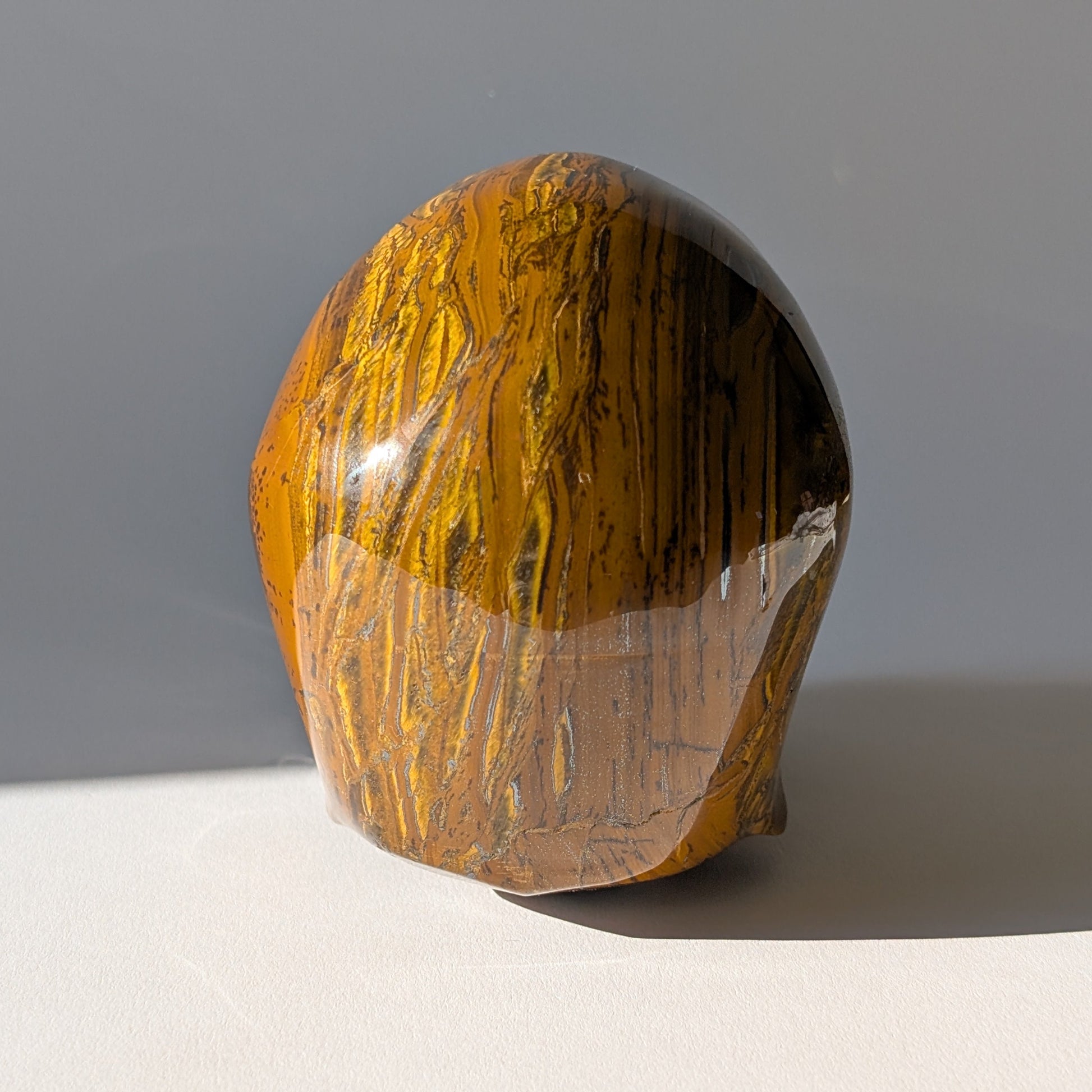 Großer Kristallschädel "Mekil" (1.32kg) aus gebändertem Tigereisen mit Goldschimmer.