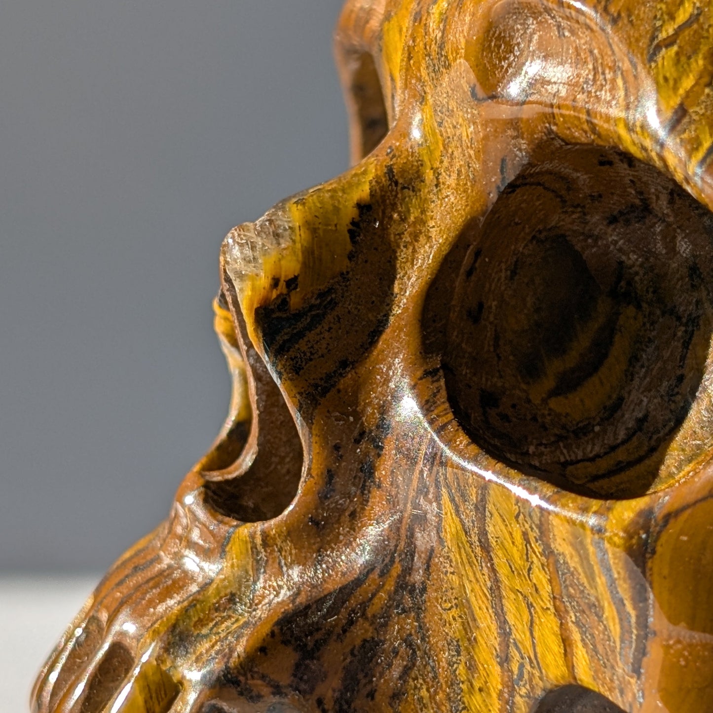 Großer Kristallschädel "Mekil" (1.32kg) aus gebändertem Tigereisen mit Goldschimmer.