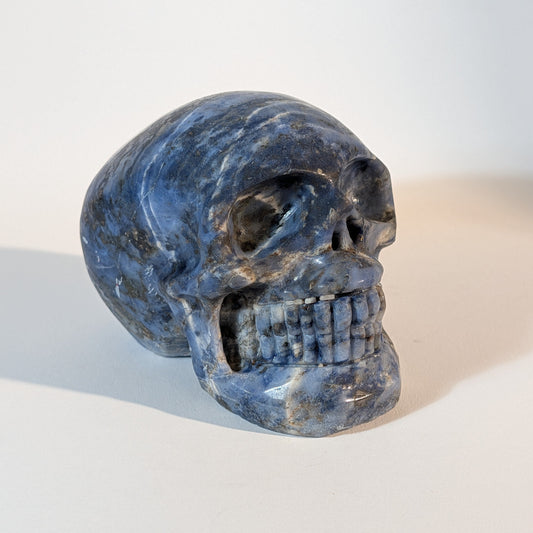 Großer, handgeschnitzter Kristallschädel Ightisa aus tiefblauem Sodalith, 894 Gramm schwer, mit weißen Calcit-Adern für Intuition und Wahrheit.