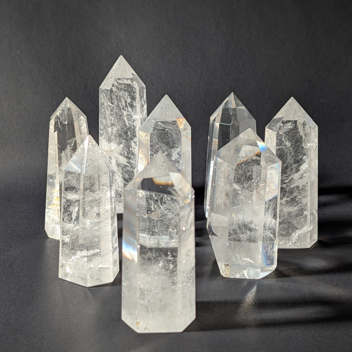 Gruppe von klaren Bergkristall Spitzen A+ Qualität, stehende Edelstein Obelisken aus Indien vor dunklem Hintergrund