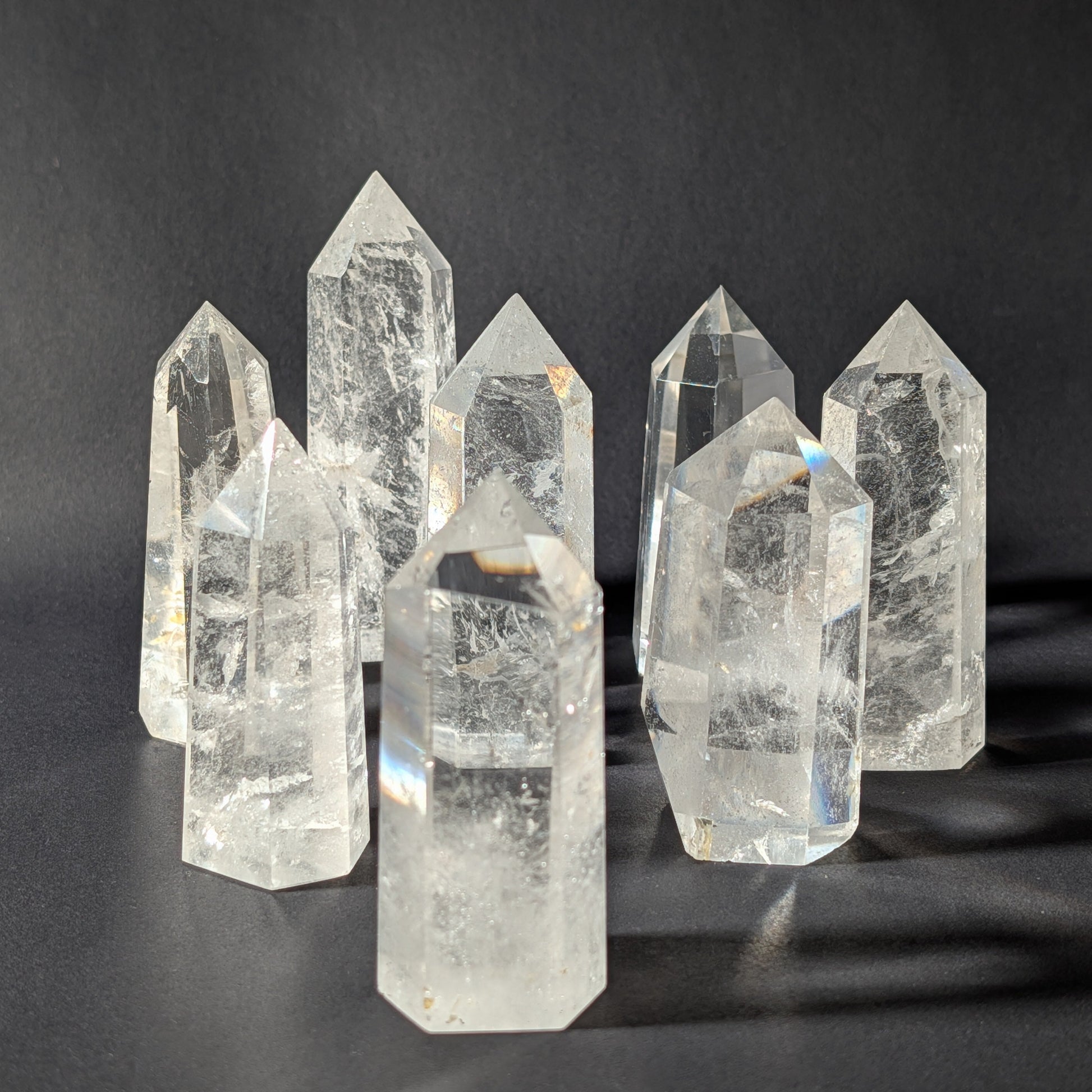 Gruppe von klaren Bergkristall Spitzen A+ Qualität, stehende Edelstein Obelisken aus Indien vor dunklem Hintergrund
