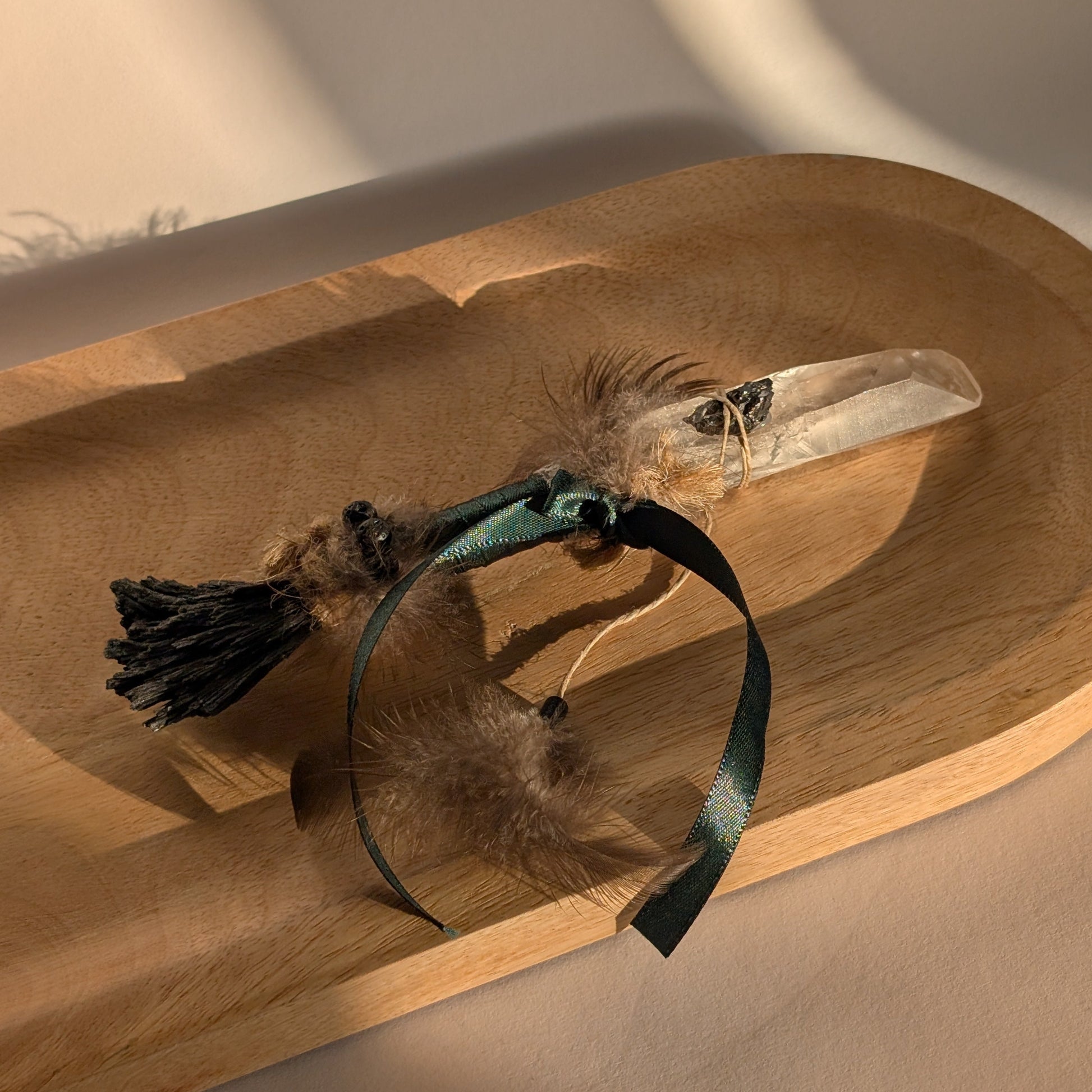 Handgefertigter Zauberstab mit großer Bergkristall-Spitze, verziert mit Federn, Kyanit und einem grünem Band.