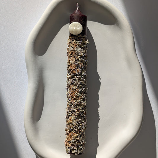 Handgegossene Vollmond Ritualkerze "Lunar Abundance" mit Kräutern in einem Glasgefäß.