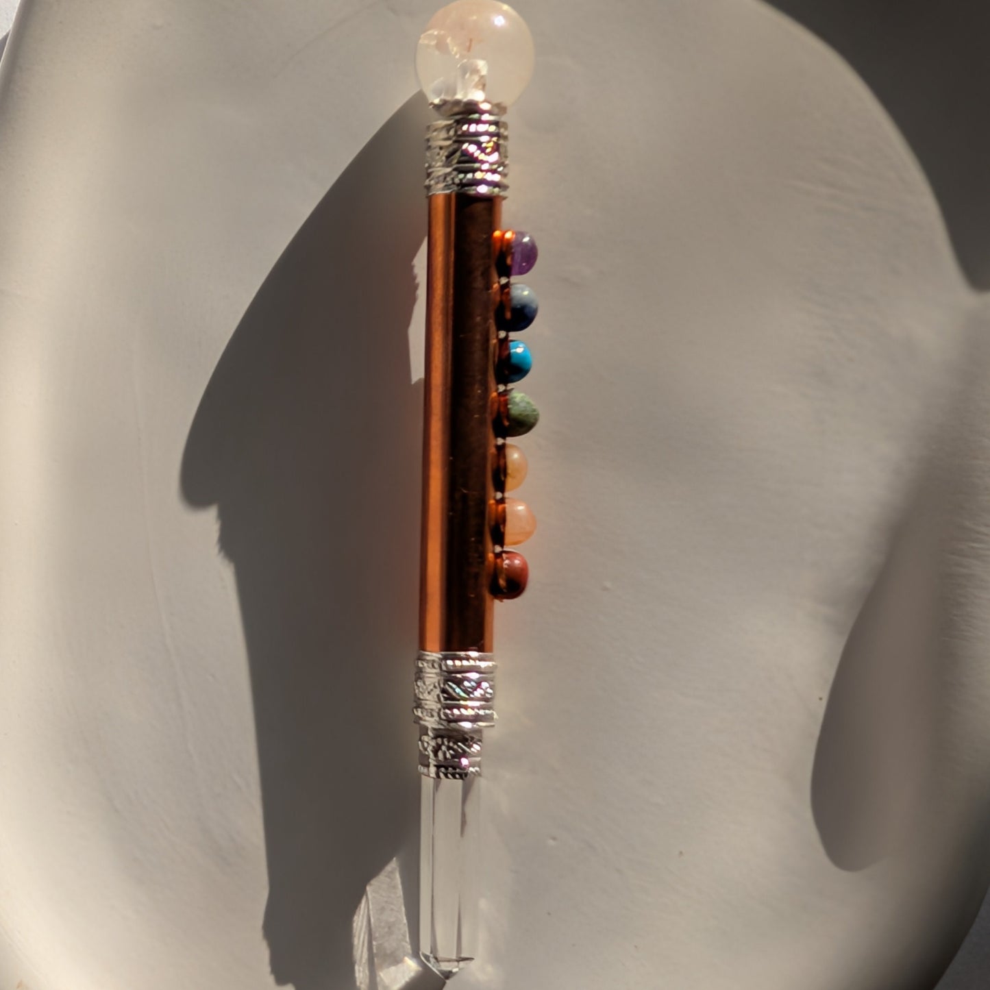Handgehaltener Chakra-Stab aus leuchtendem Kupfer mit sieben farbigen Edelsteinen und Bergkristall-Spitzen.