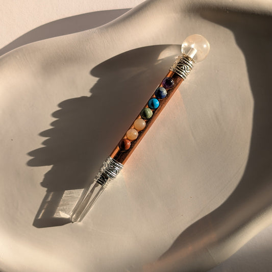 Handgehaltener Chakra-Stab aus leuchtendem Kupfer mit sieben farbigen Edelsteinen und Bergkristall-Spitzen.