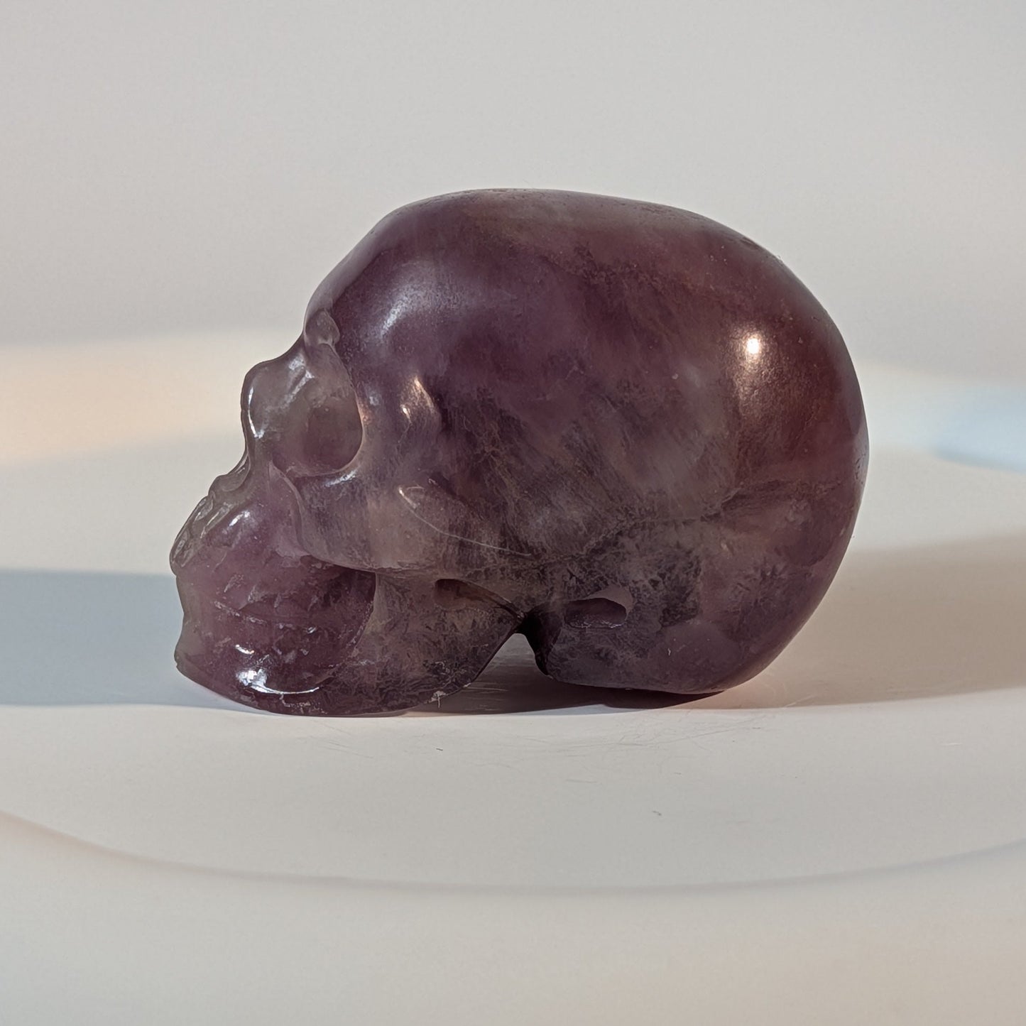 Handgeschnitzter Kristallschädel Katras aus echtem, violettem Fluorit, 97 Gramm schwer, mit markanter, gerader Farbbänderung für Konzentration und Fokus.