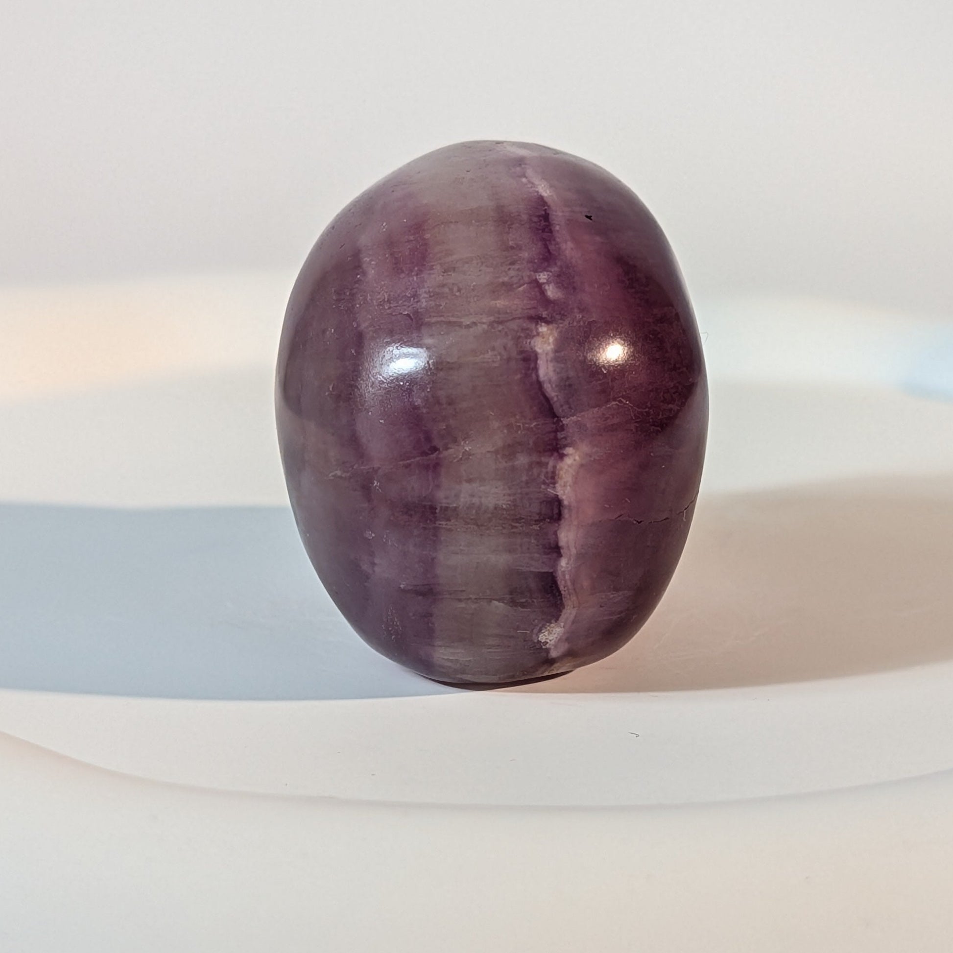 Handgeschnitzter Kristallschädel Katras aus echtem, violettem Fluorit, 97 Gramm schwer, mit markanter, gerader Farbbänderung für Konzentration und Fokus.