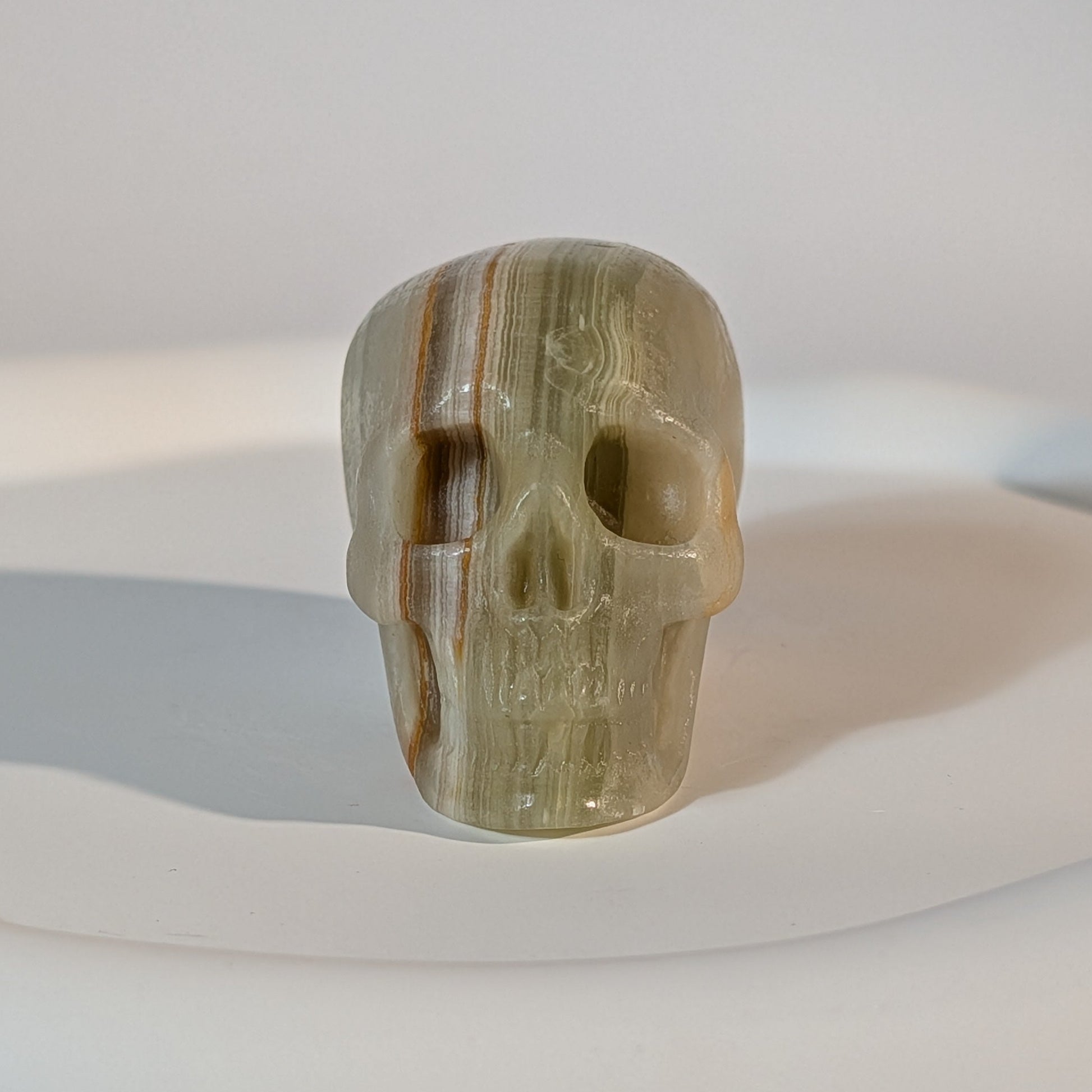 Handgeschnitzter Kristallschädel Kerwen aus grün-braunem Bänder-Aragonit (Grüner Onyx), 78 Gramm schwer, für emotionale Balance und Geduld.