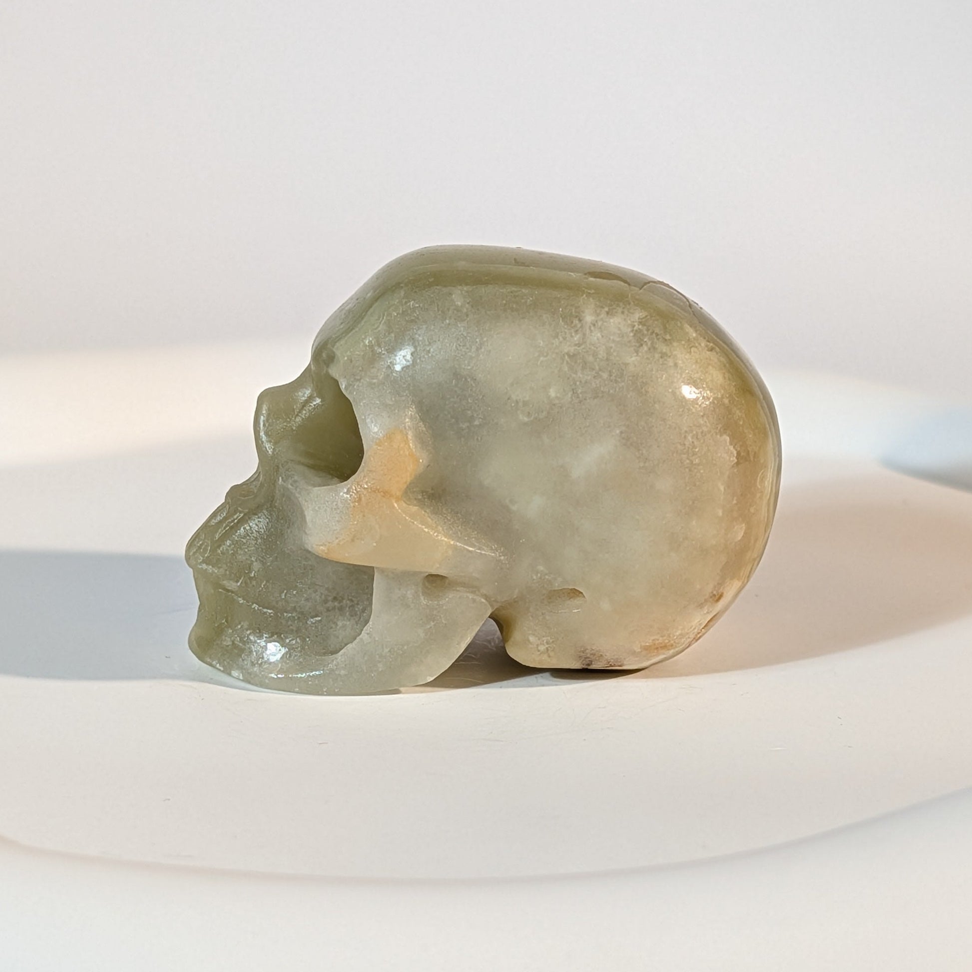 Handgeschnitzter Kristallschädel Kerwen aus grün-braunem Bänder-Aragonit (Grüner Onyx), 78 Gramm schwer, für emotionale Balance und Geduld.