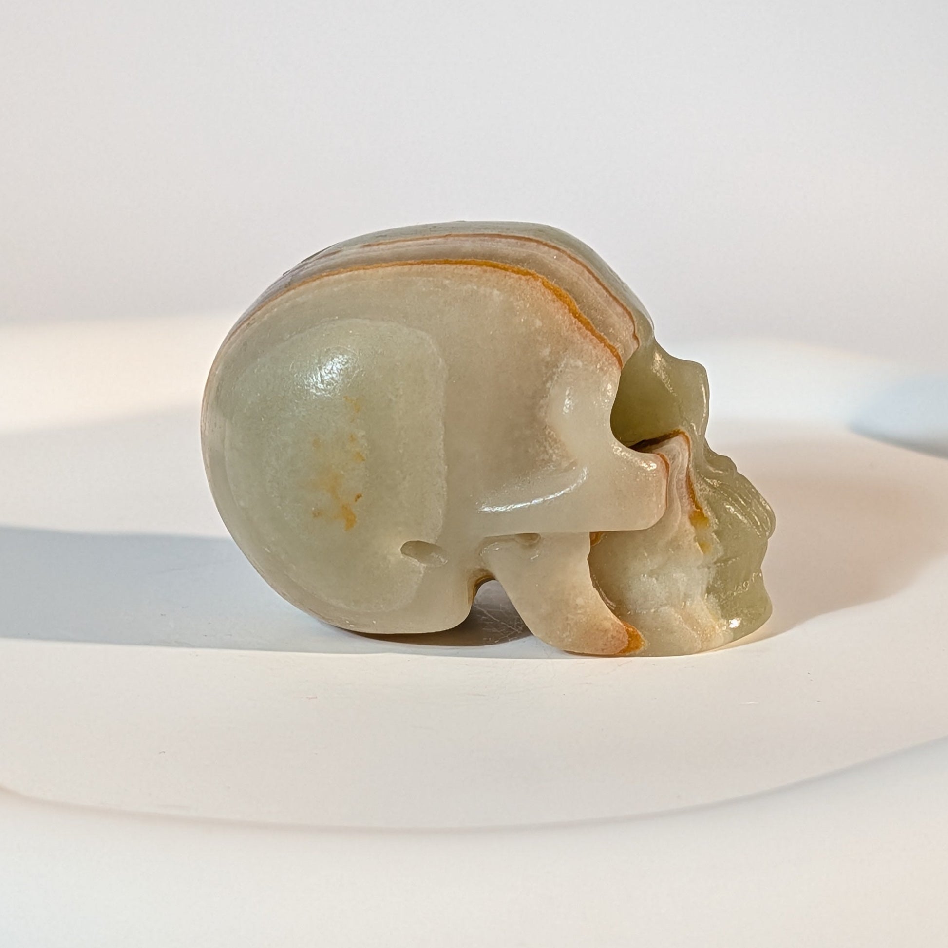 Handgeschnitzter Kristallschädel Kerwen aus grün-braunem Bänder-Aragonit (Grüner Onyx), 78 Gramm schwer, für emotionale Balance und Geduld.