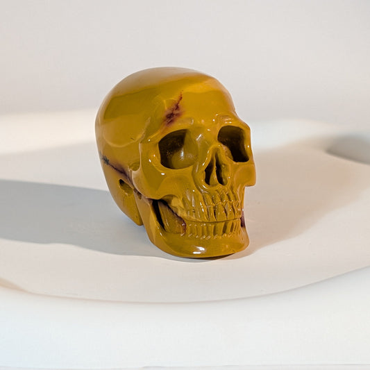 Handgeschnitzter Kristallschädel Nasira aus echtem australischem Mookait, 81 Gramm schwer, in leuchtendem Senfgelb mit einer bordeauxroten Ader.