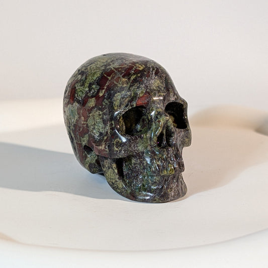 Handgeschnitzter Kristallschädel Orthanc aus dunkelgrünem Heliotrop (Blutstein), 101 Gramm schwer, mit roten Einschlüssen für Mut und Schutz.