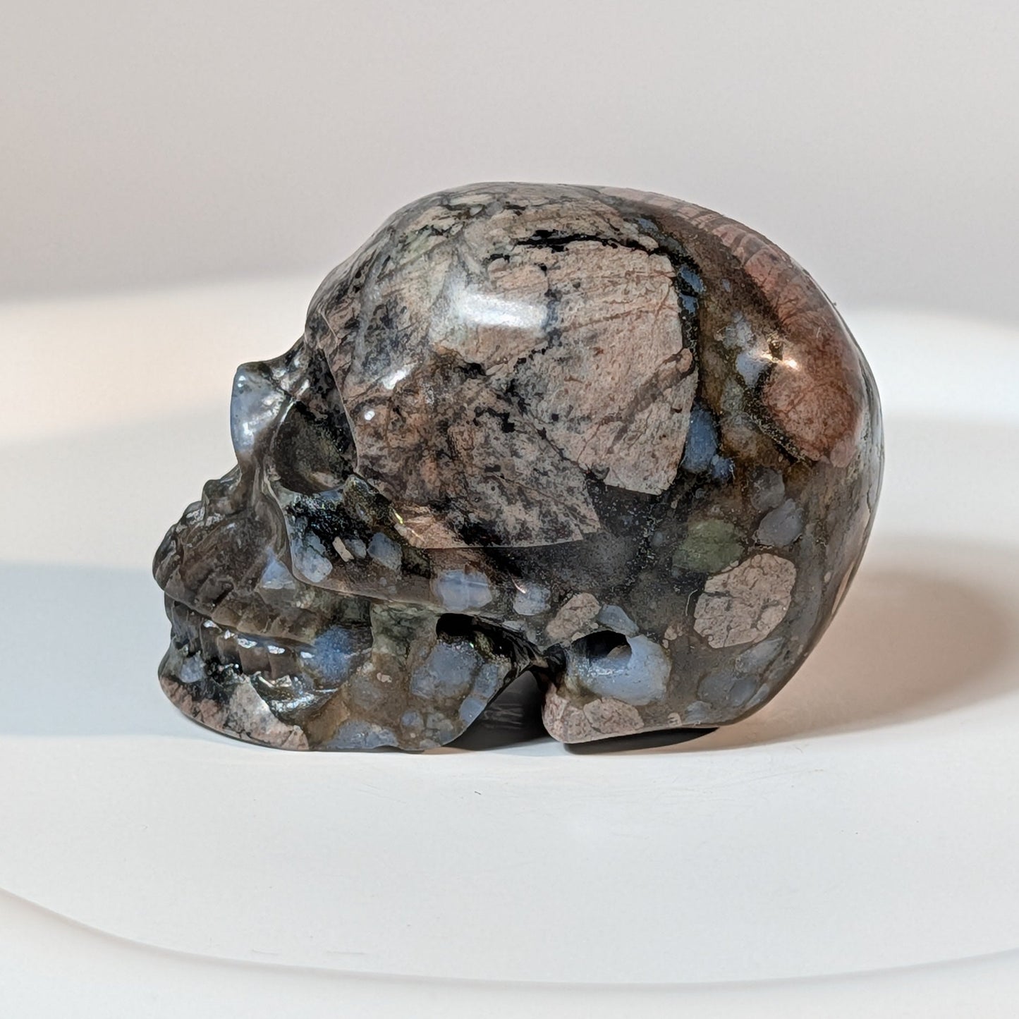 Handgeschnitzter Kristallschädel Zugan aus seltenem Que Sera Stein (Llanit), 79 Gramm schwer, mit rosa Feldspat und seltenen blauen Quarz-Einschlüssen.