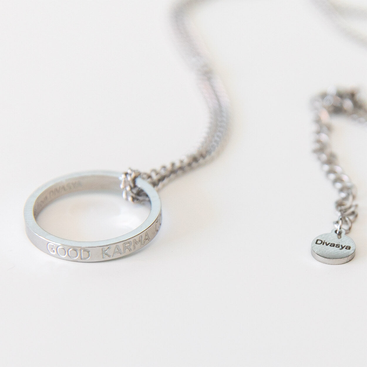 Silberfarbener Ring der Kette in Detailansicht mit Gravur